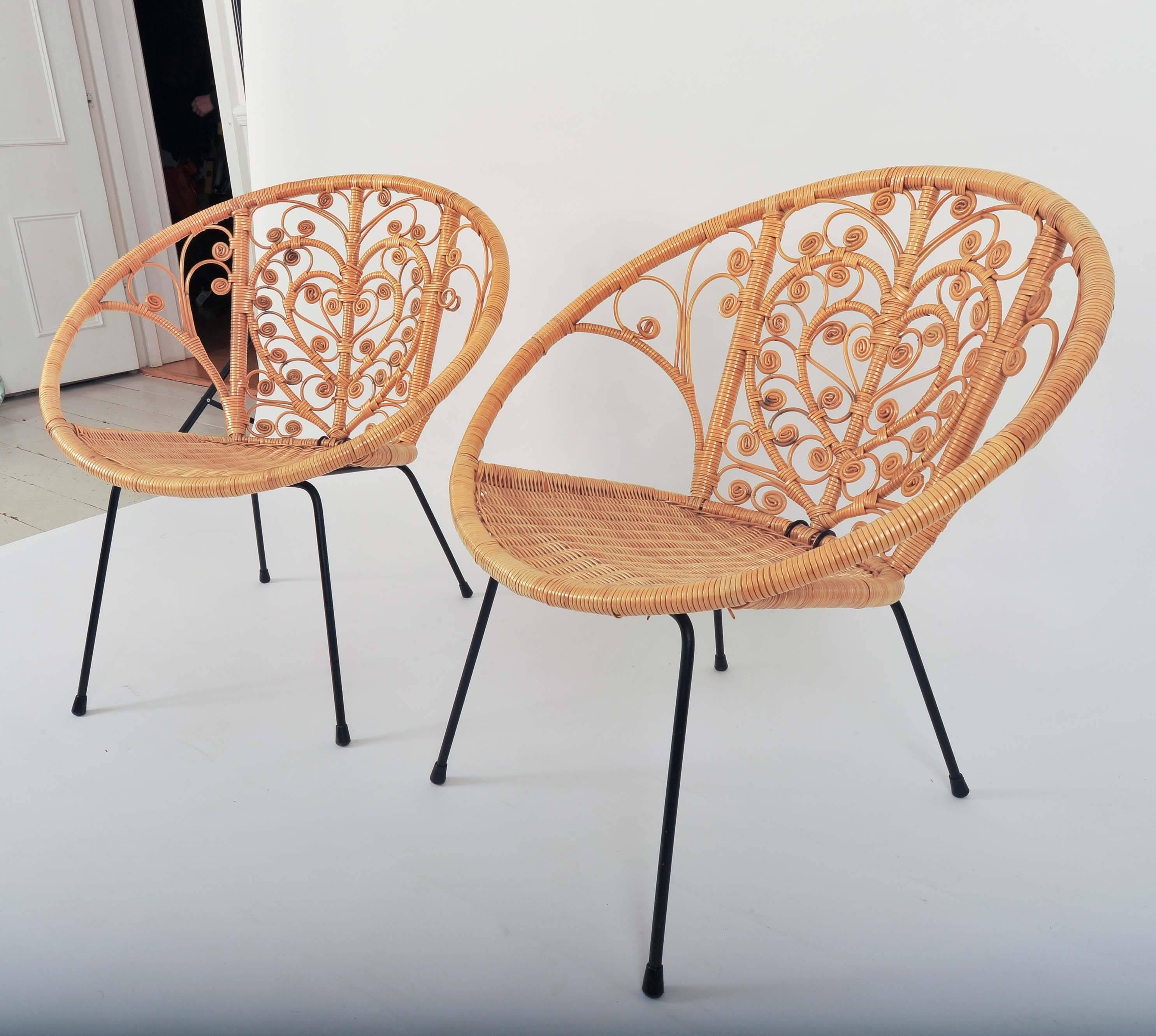 A fabulous pair of 1960s bucket rattan chairs with heart shaped design. These chairs are in exceptional condition.