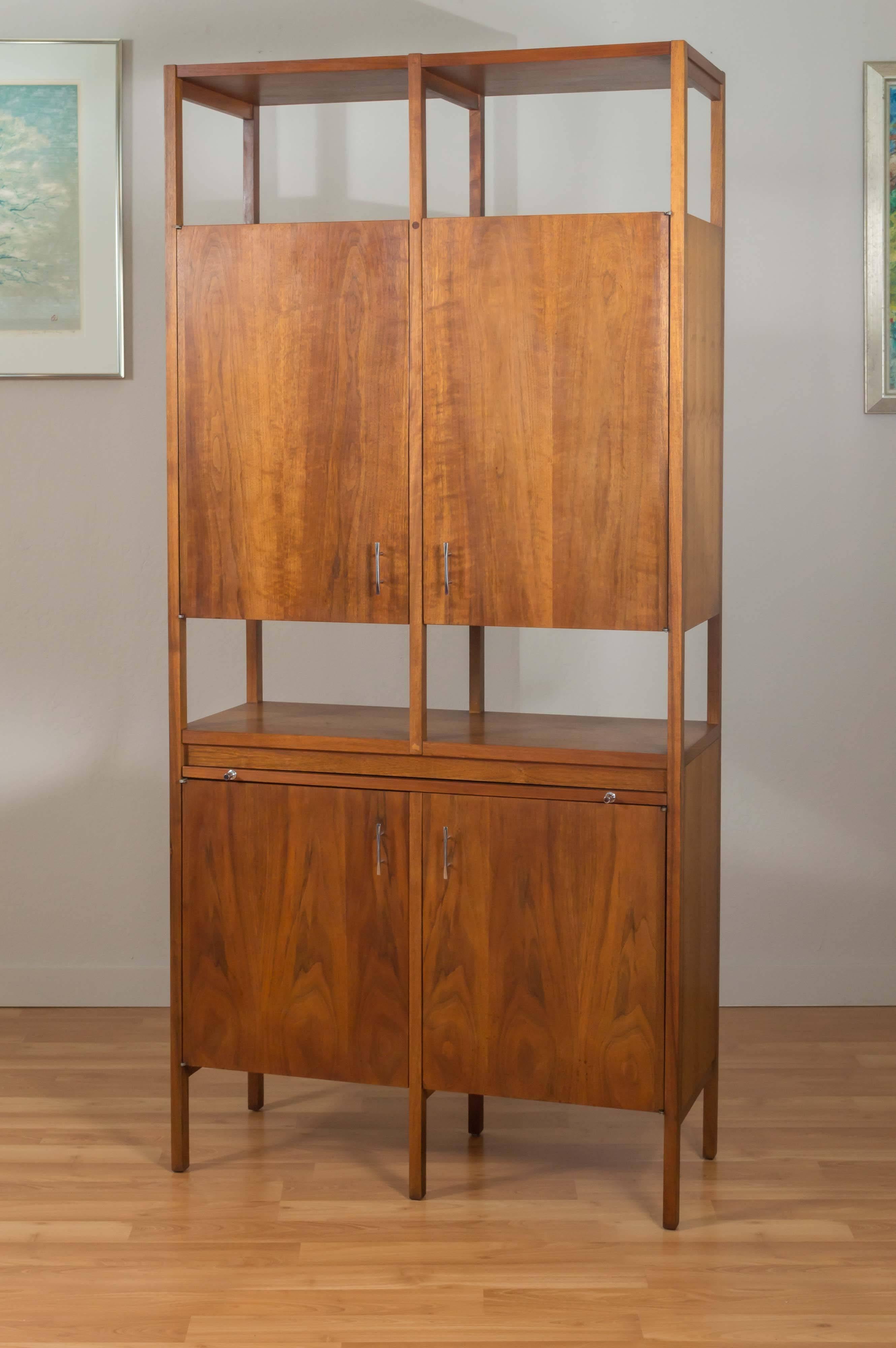 Towering and rare four-door dry bar or tall cabinet by Paul McCobb for Lane’s “Delineator” series. Walnut, with immaculate pull-out black laminate serving surface and original polished metal pulls. Each upper cabinet contains a large storage