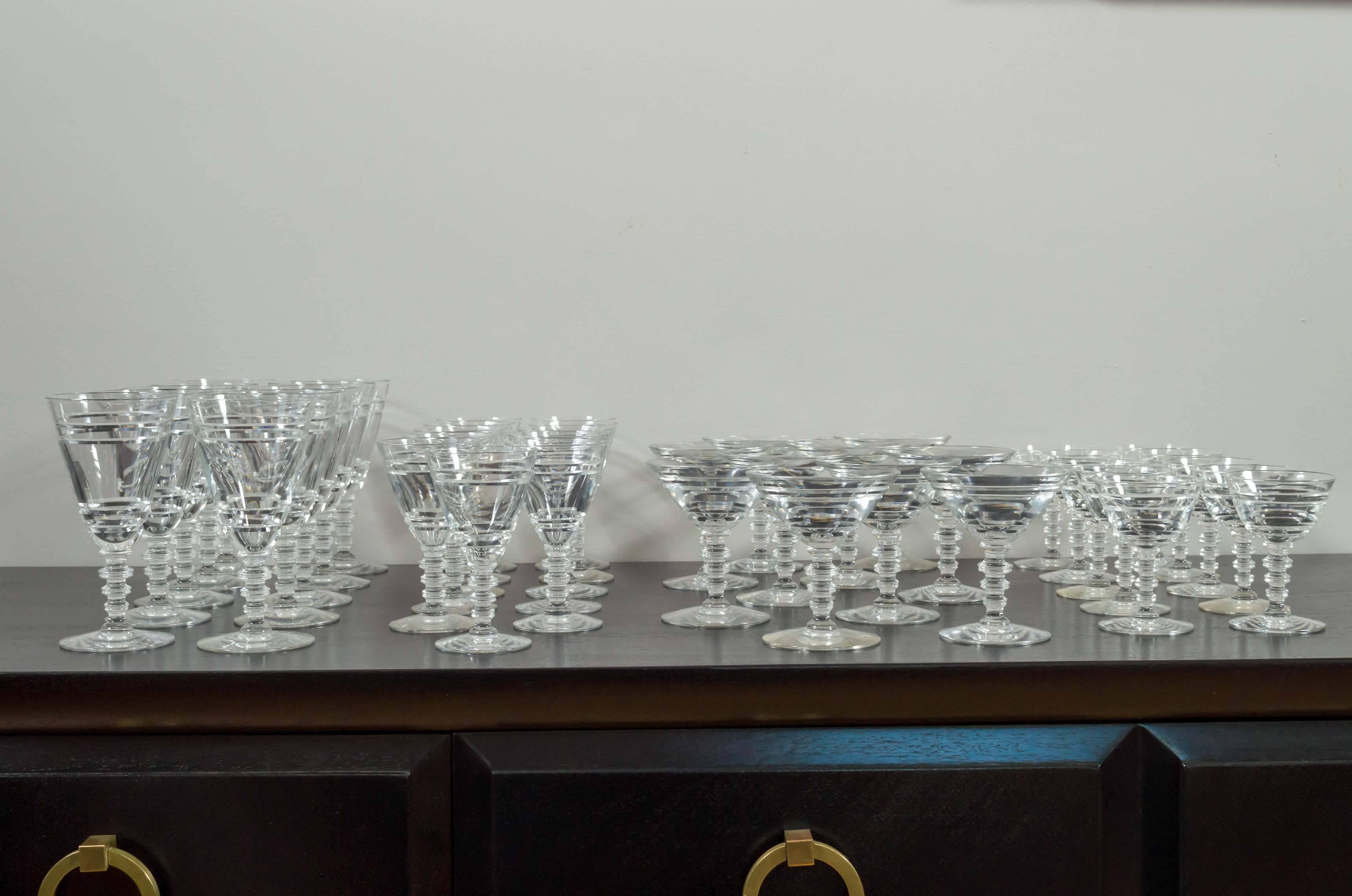 A sparkling service-for-ten set of Art Deco-era stemware, expertly crafted from Steuben lead crystal blanks by T.G. Hawkes & Co., the preeminent American producer of the finest cut-glass of the time. 

The concentric simplicity of their design