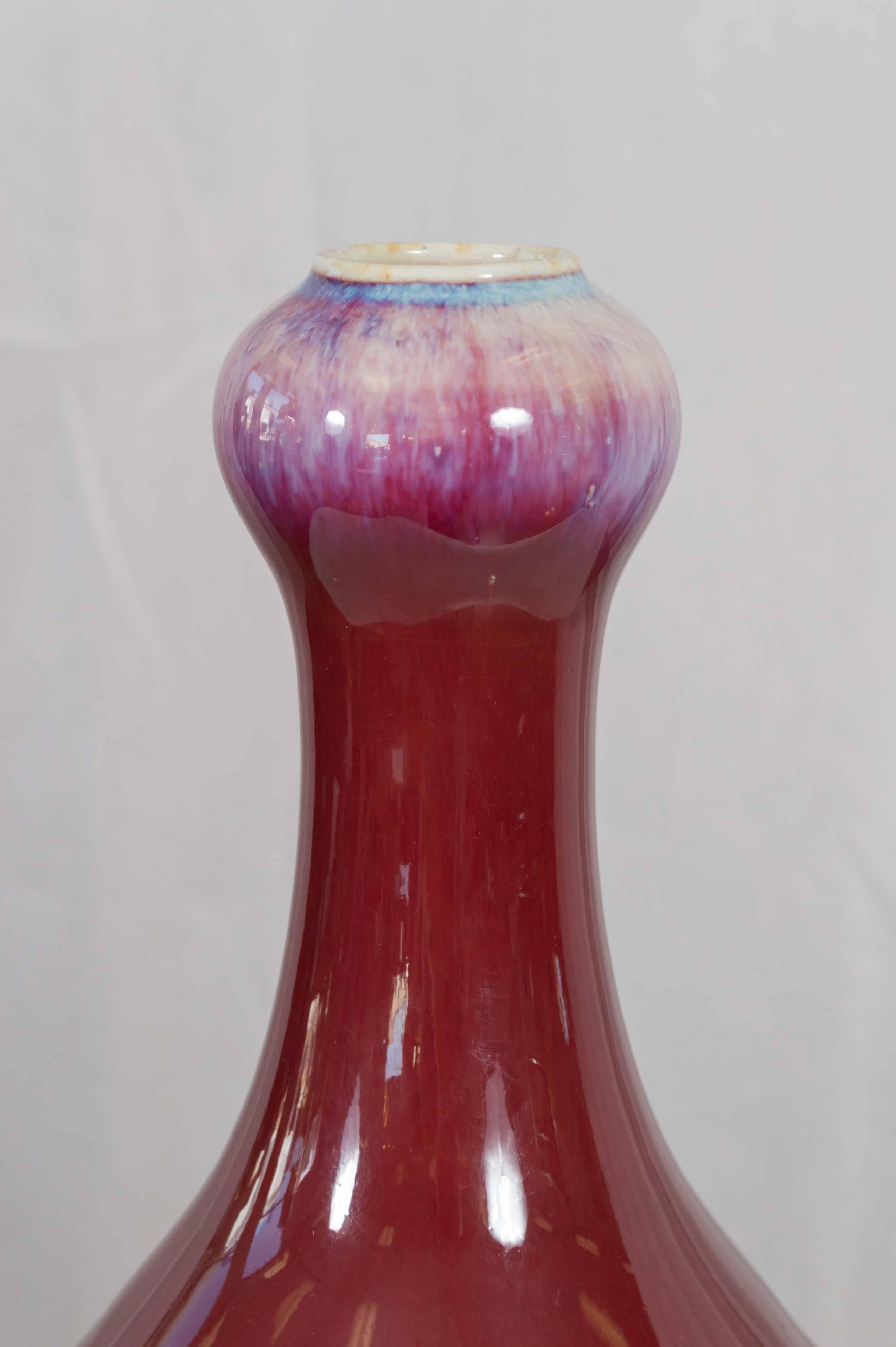 Its wonderfully proportioned pear-shaped form is significant in scale, with an imposing yet elegant Silhouette. Body and neck are finished in a deep, rich and lustrous sang de boeuf glaze. The beautiful hues of its bulbous, white-lipped mouth