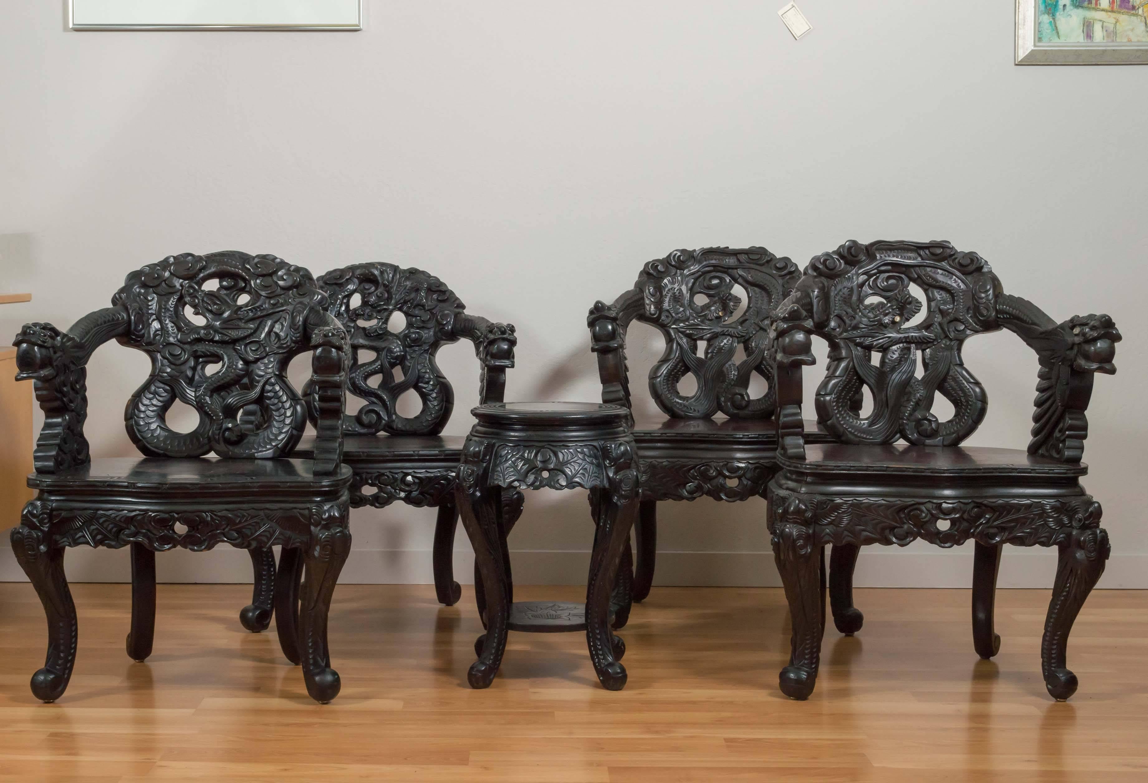 A very expressive pair of ebonized and embellished antique Chinese chairs that feature a fierce, deeply carved dragon motif.

Hand crafted out of a heavy mahogany-type wood, they have an ebonized finish with the exception of ample, dark