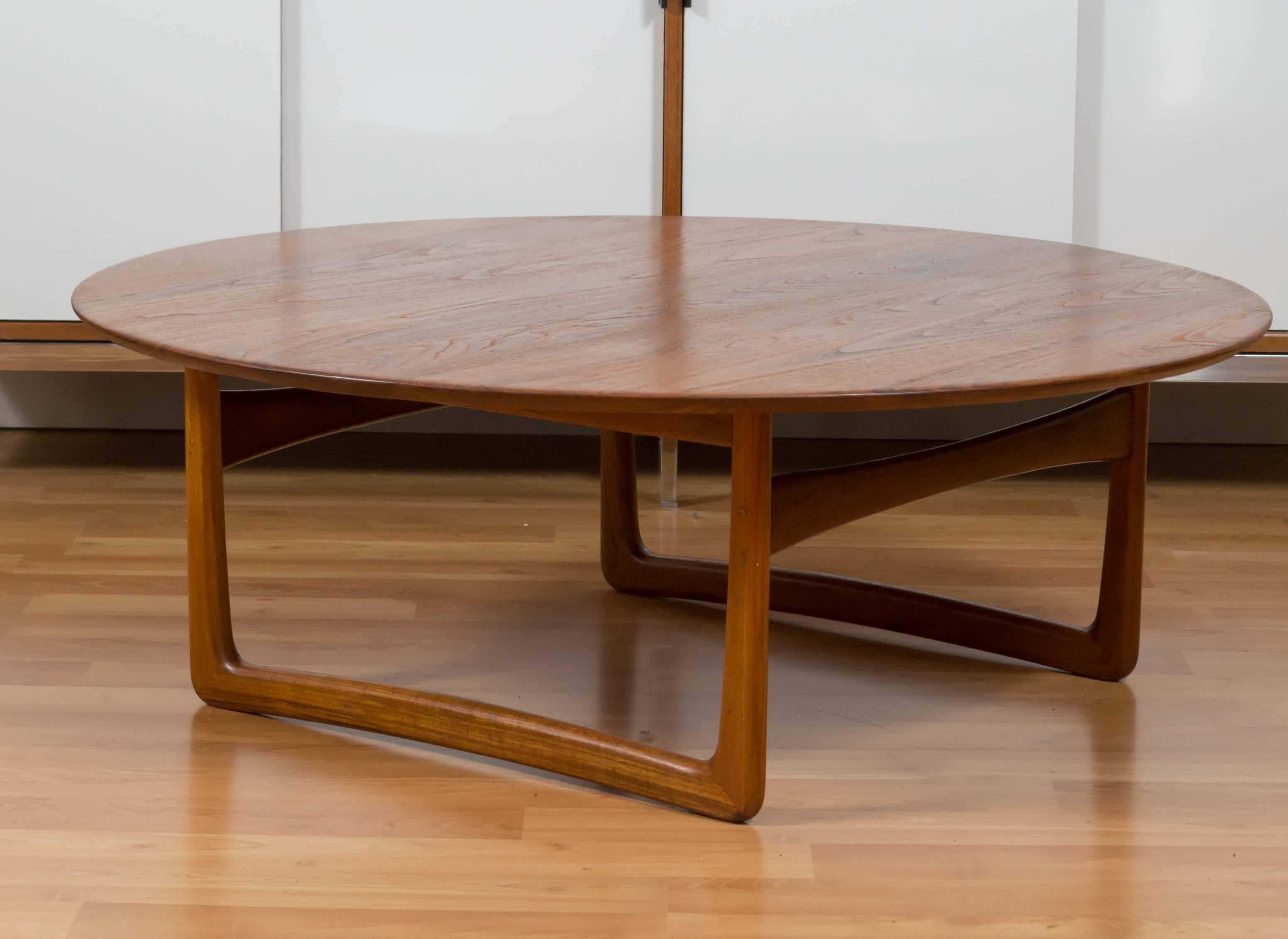 This impressive France & Daverkosen (later France & Son) solid teak coffee table was designed by Orla Mølgaard for John Stuart.

Its expansive bevel edge circular top sits upon a sculpted sled base. The table has been professionally refinished, so