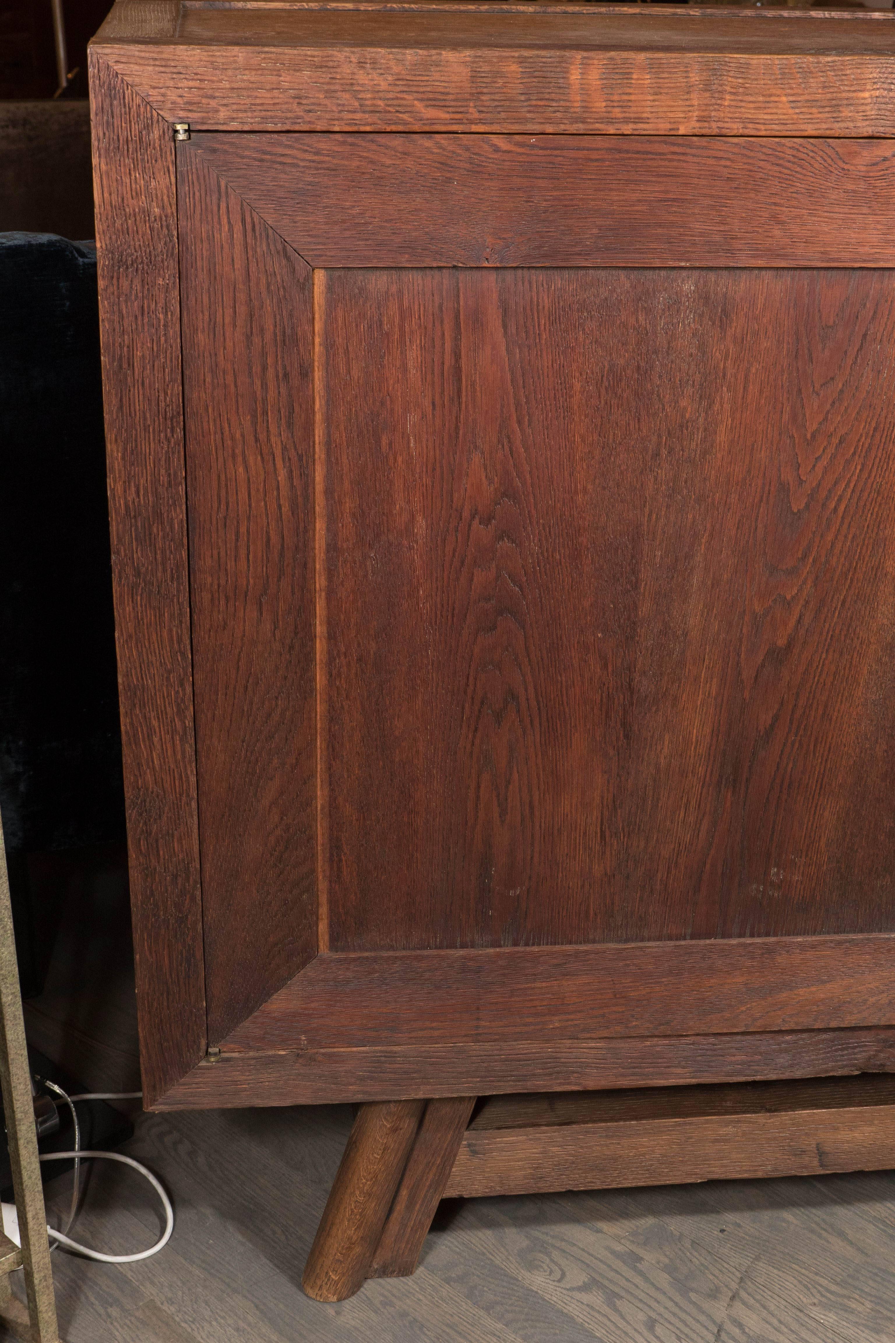 Exceptionally rare custom French Art Deco sideboard in open grain oak by Jean Dunand. Two lock-and-key doors open to reveal shelving as well as a single-pull drawer. Very solid construction and minimal deco design really highlight the wonderful open