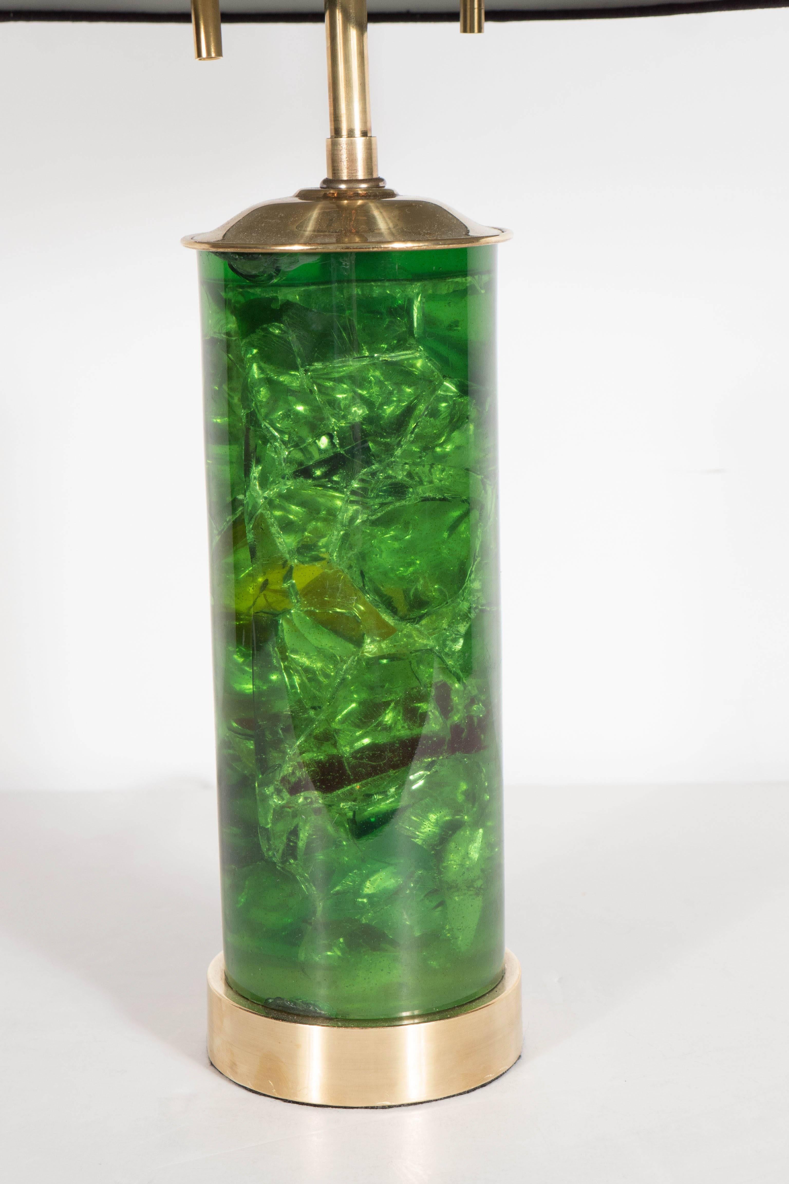 This stunning table lamp from the 1970s features an emerald fractured resin base on a brushed brass mount and fittings. The fractures in the resin catch the light creating a visual effect. The lamp has two independently operated bulbs and has been