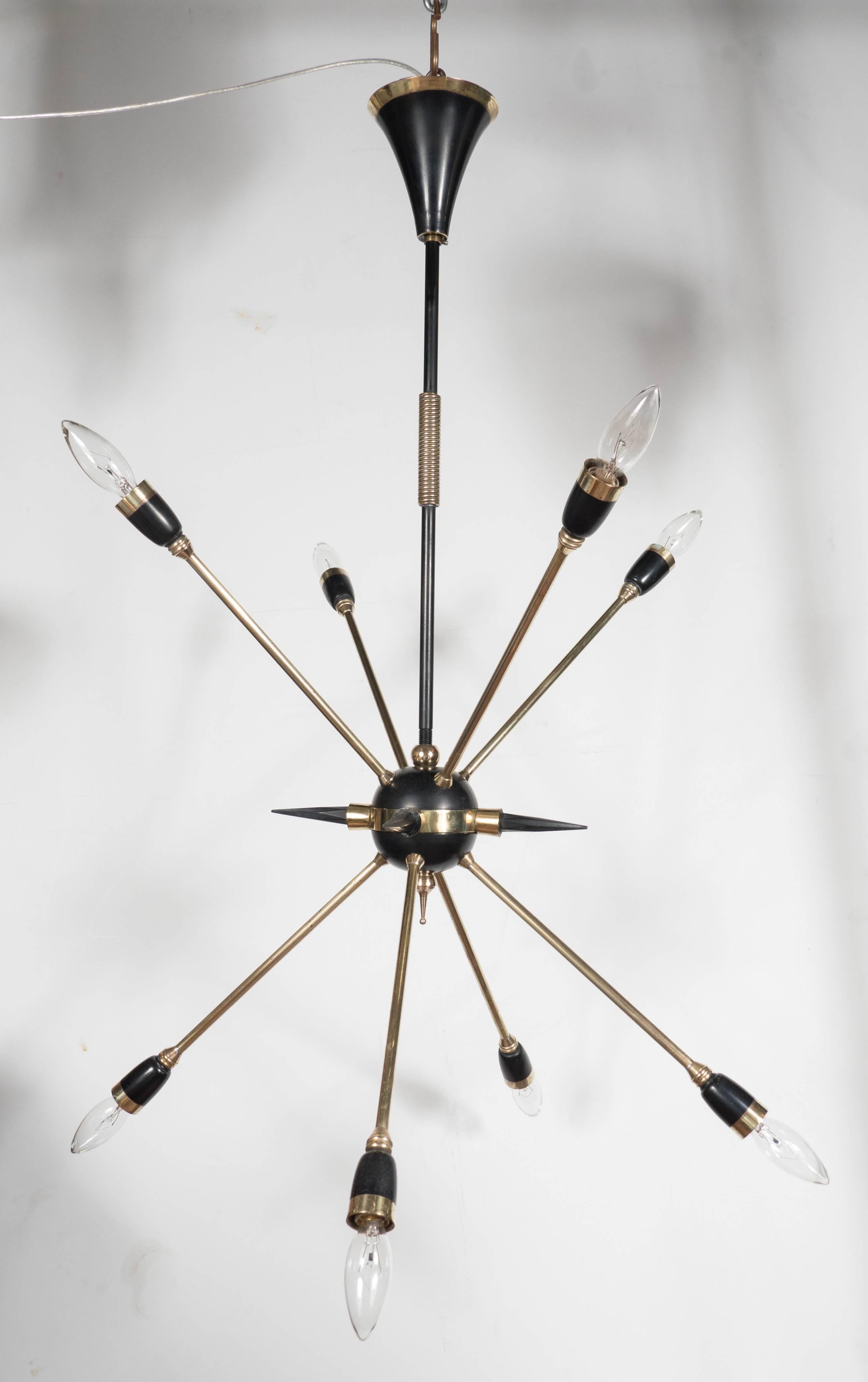 A Mid-Century Modernist Italian Sputnik chandelier with eight arms and spike detailing in the manner of Stilnovo. From a black enameled central ball stem four spikes and eight arms, each of which support a candelabra socket. Brass detailing