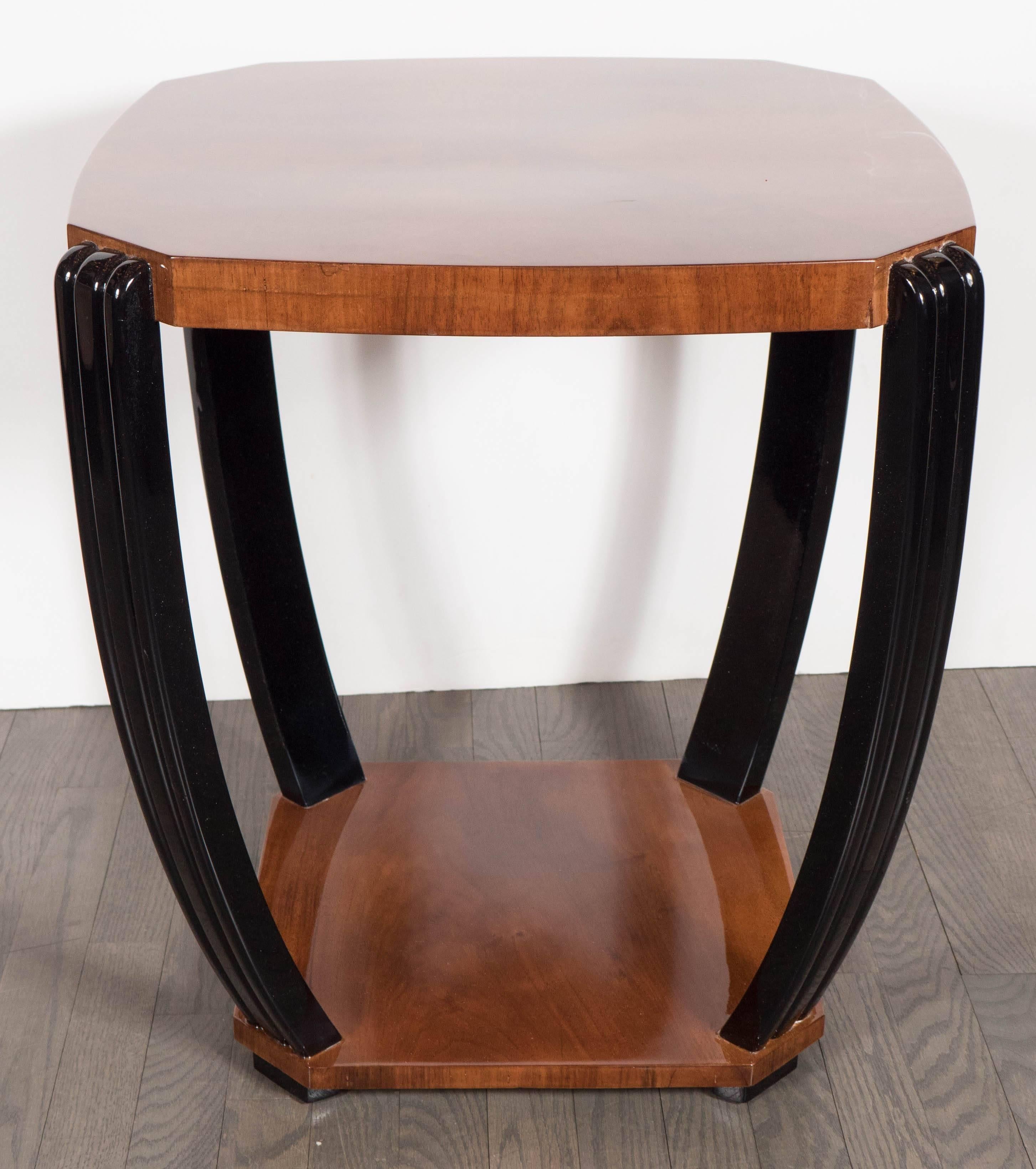An Art Deco streamlined bookmatched burled walnut occasional table. Lacquered fluted legs with ribbed detailing connect the base to a polished, symmetrical-cut slightly curved top. This piece has been restored to mint condition.