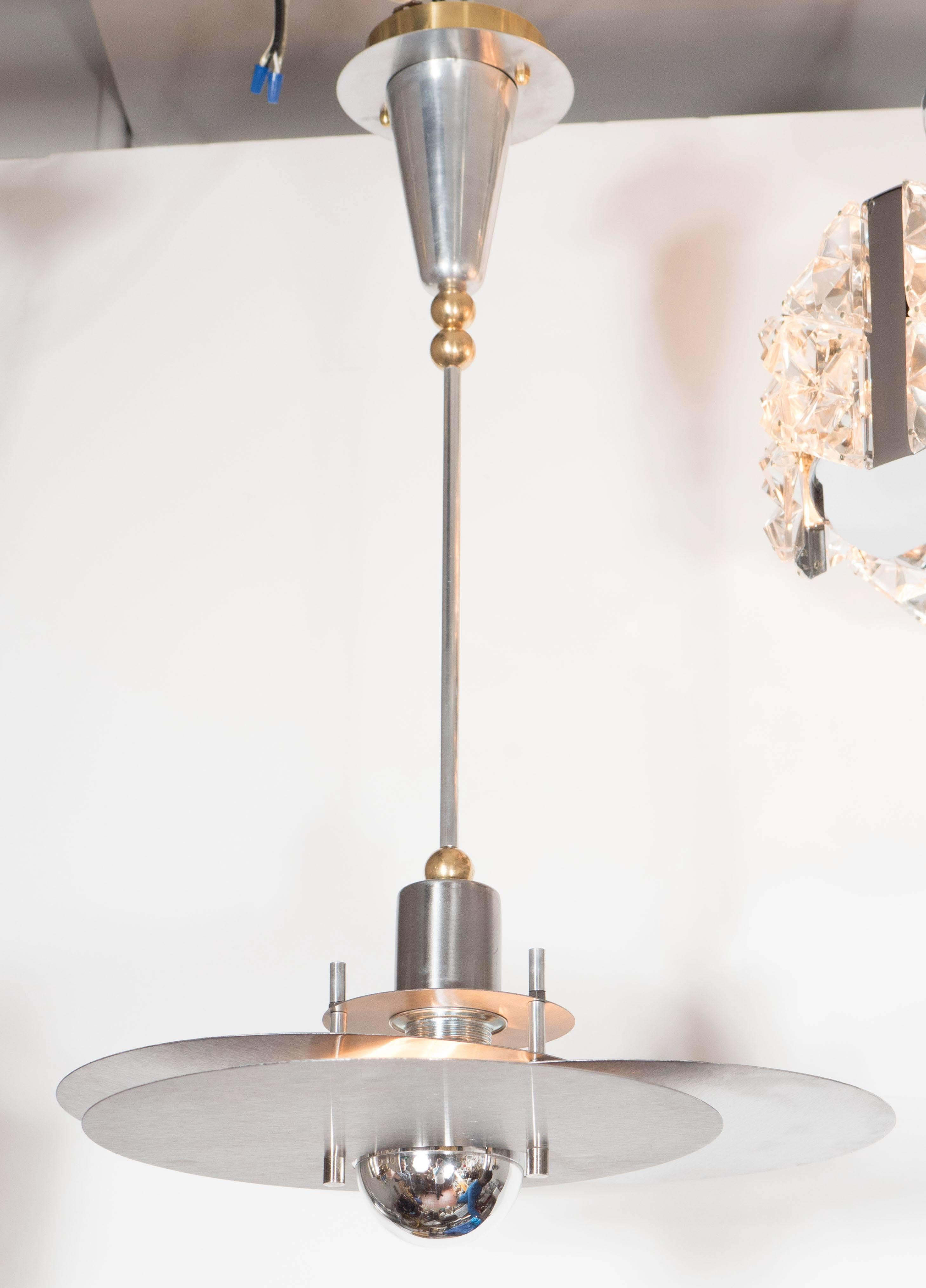 This sculptural Mid-Century Modernist chandelier consists of circular polished aluminum geometric elements configured in a stacked over-lapping fashion. Suspended by a rod with brass ball adornments and a conical shaped canopy. Newly rewired and