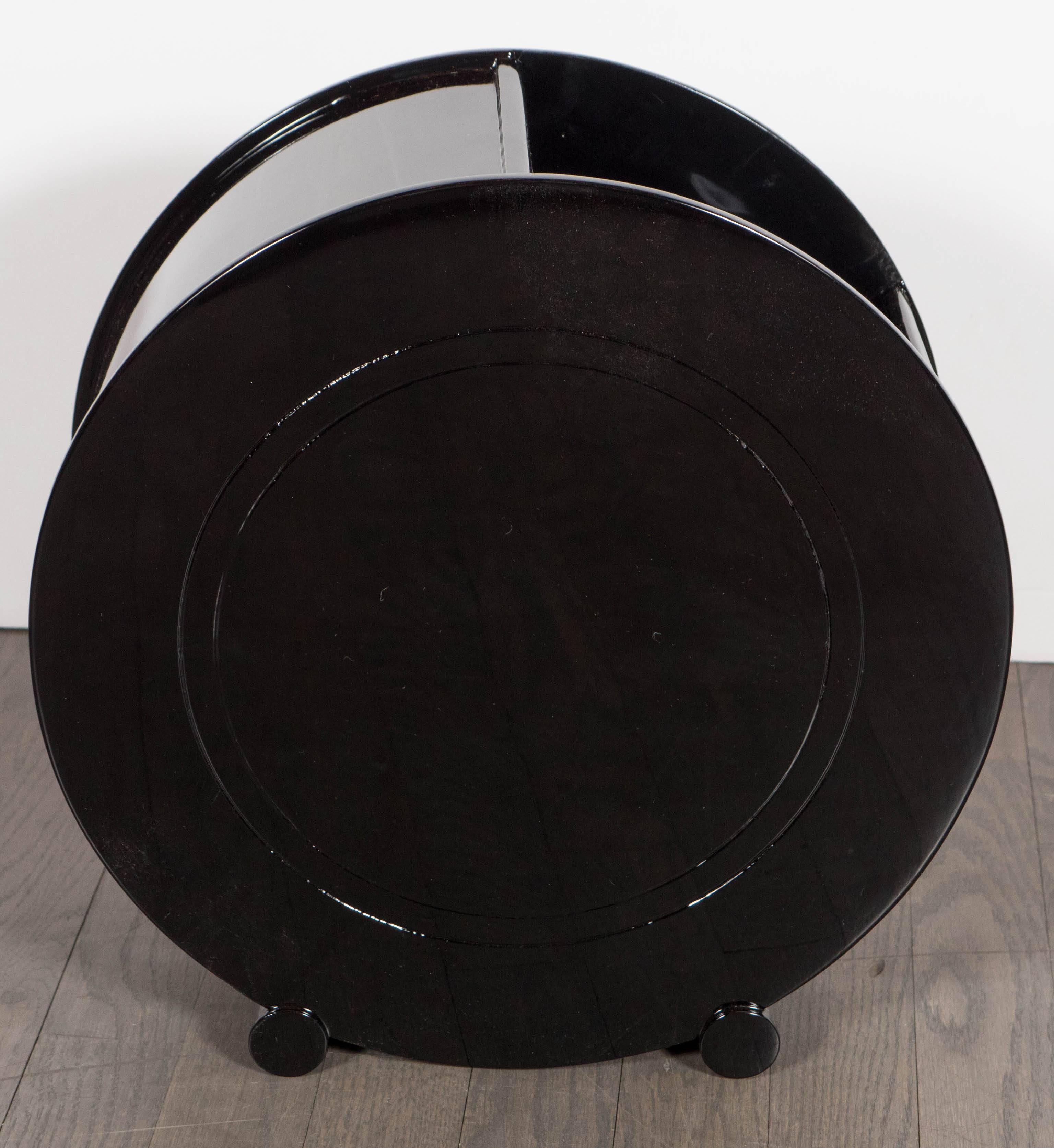 A rare and exceptional Art Deco machine age waste basket attributed to Donald Deskey, finished in black lacquer with a circular streamlined design. It features a concentric circular etched detail following the form. Restored to mint condition.