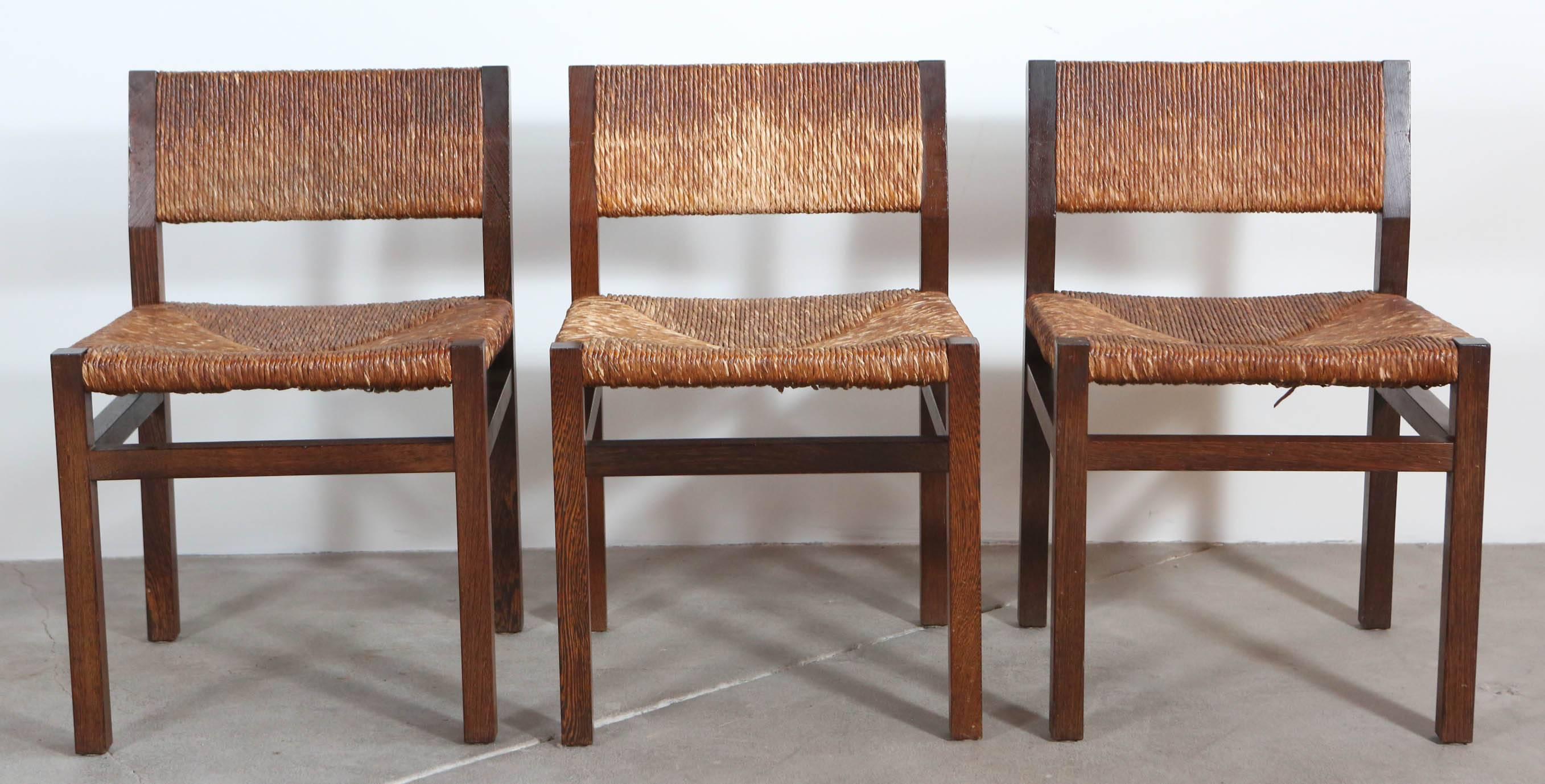 Set of Two armless dining chairs with rush seat and back with a dark oak frame.