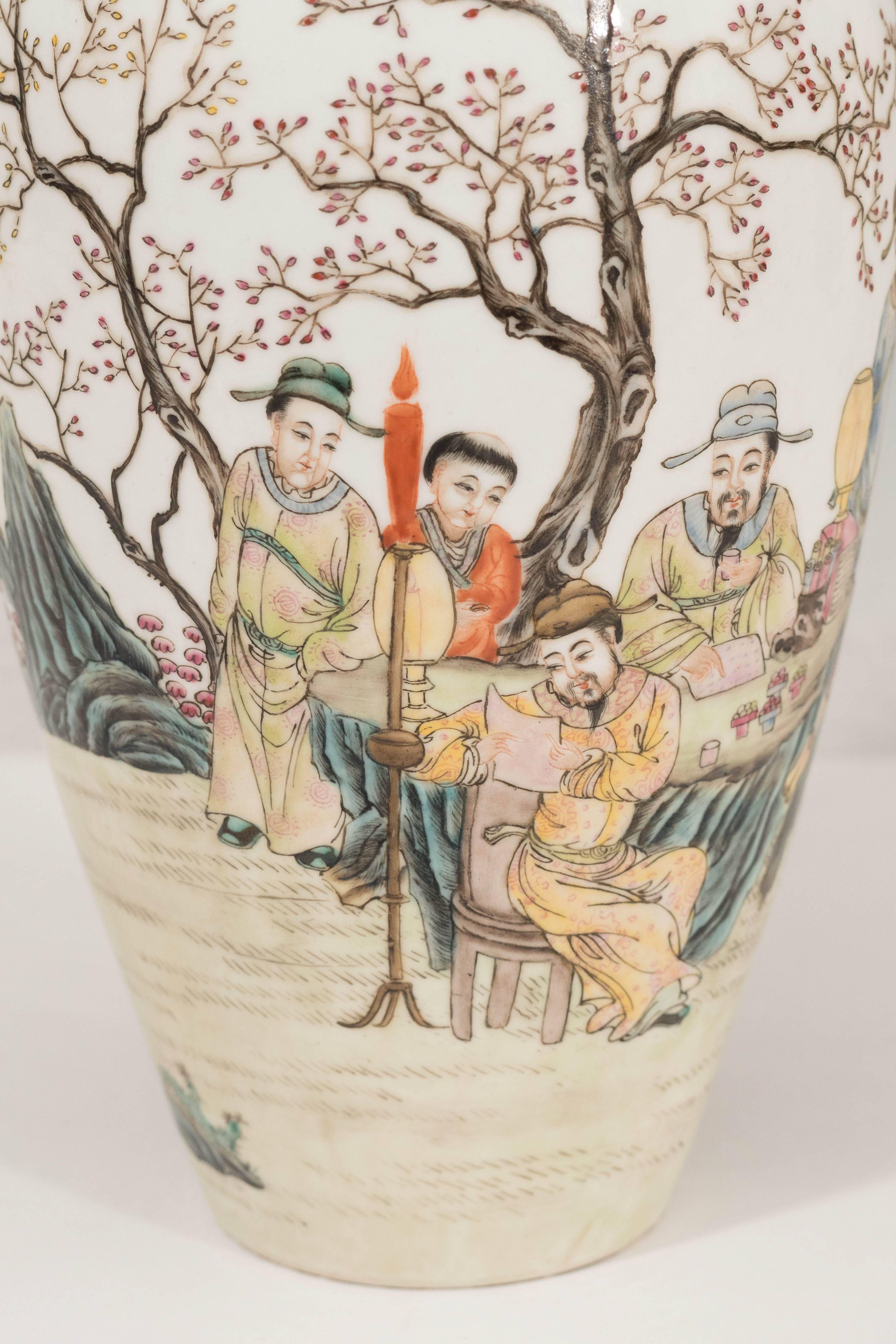 A Chinese baluster form vase with gilded rim, produced within the early to mid-20th century period, in hand-painted and glazed porcelain, depicting a gathering of figures within the natural setting. Stamped to underside with four-character Qianlong