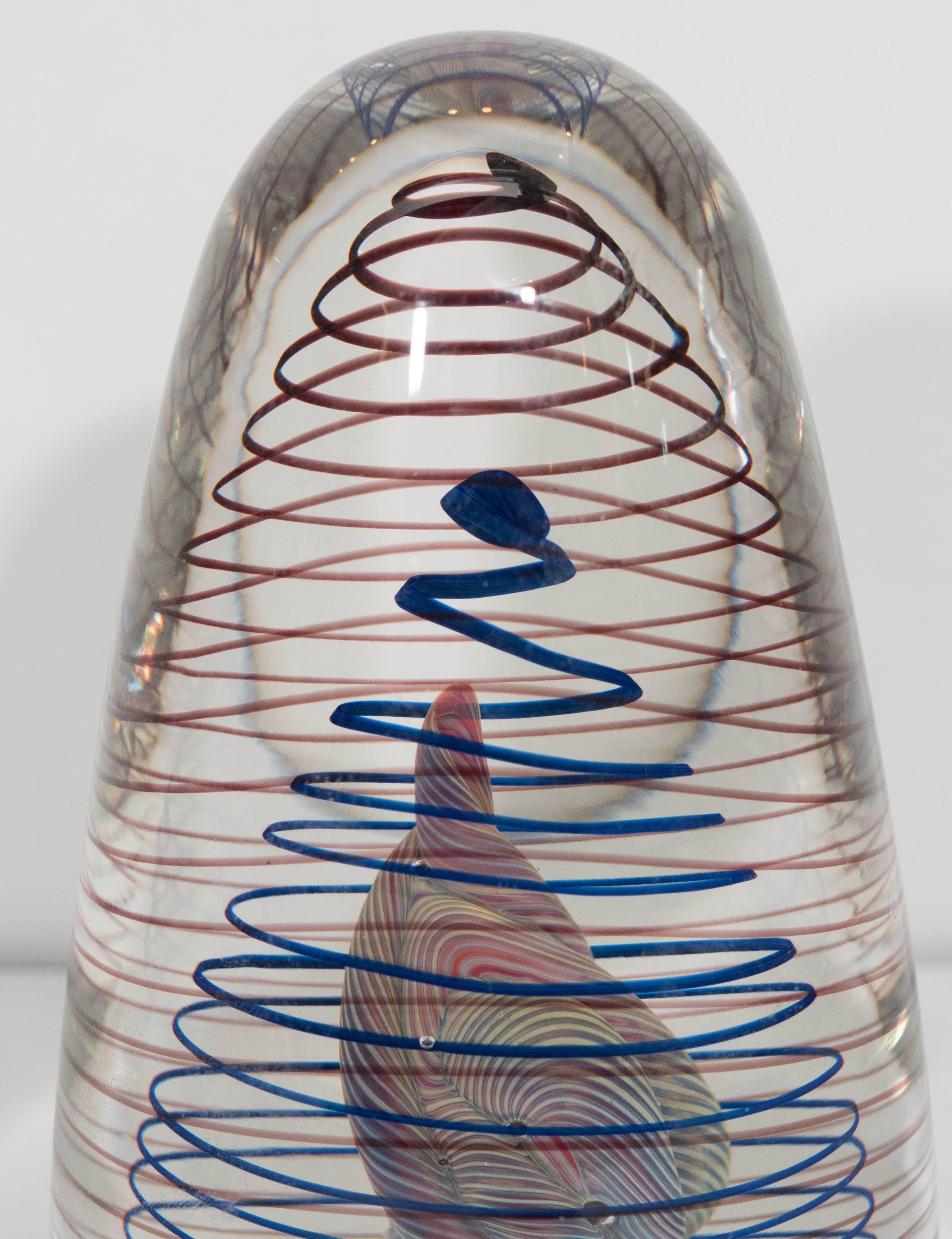 An elaborate handblown glass paperweight, produced within the late 20th century by artist Henry Summa, crafted into a rounded egg shape, with intricate cane work. Signed [HS Dec EV 12-33] to the underside. This piece remains in excellent condition,