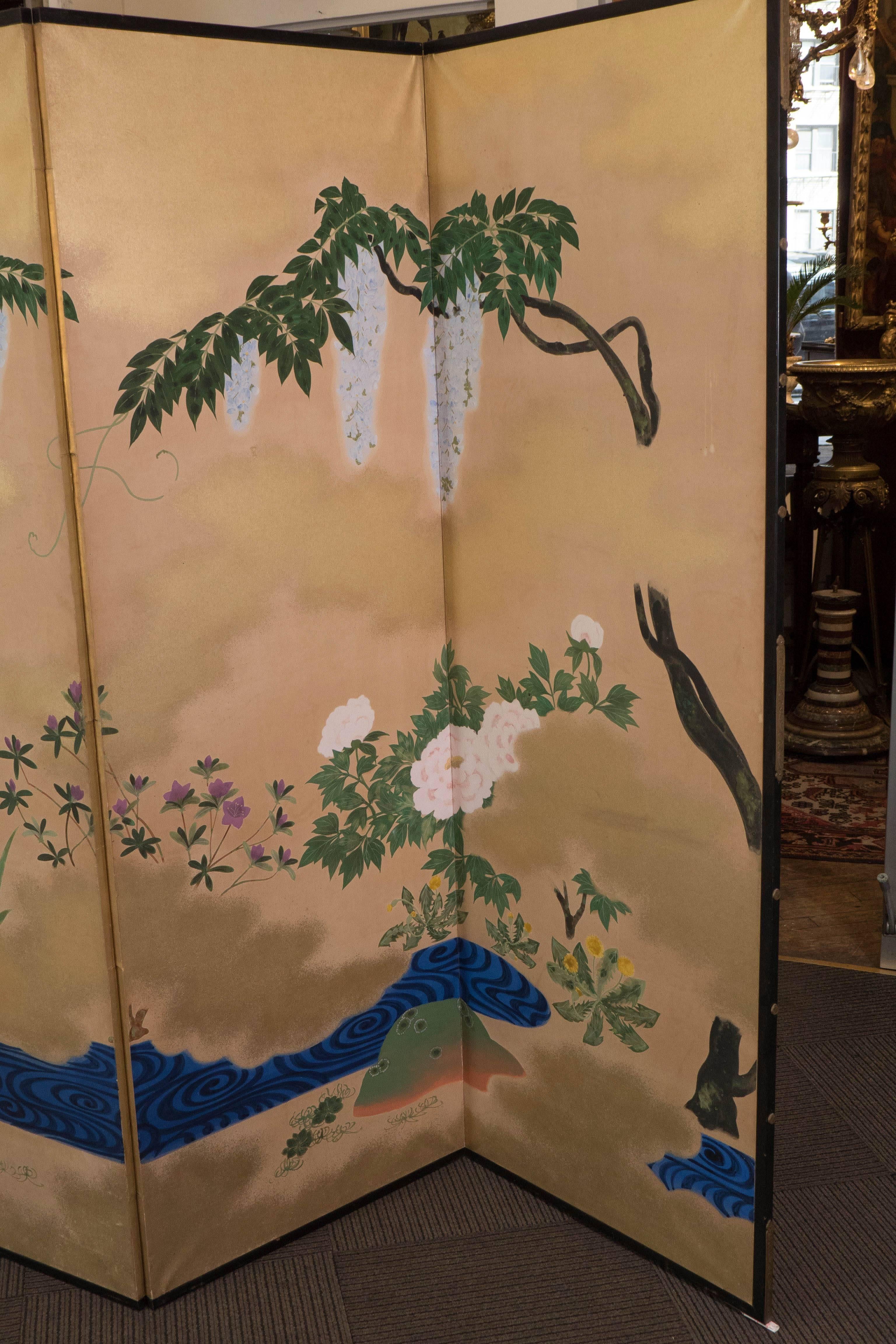 An elegant six panel screen, produced in Japan within the early 20th century period, circa late Meiji to the early Showa period, which comes set within a black lacquer frame, depicting a serene blue lake scene, surrounded by hanging wisteria,