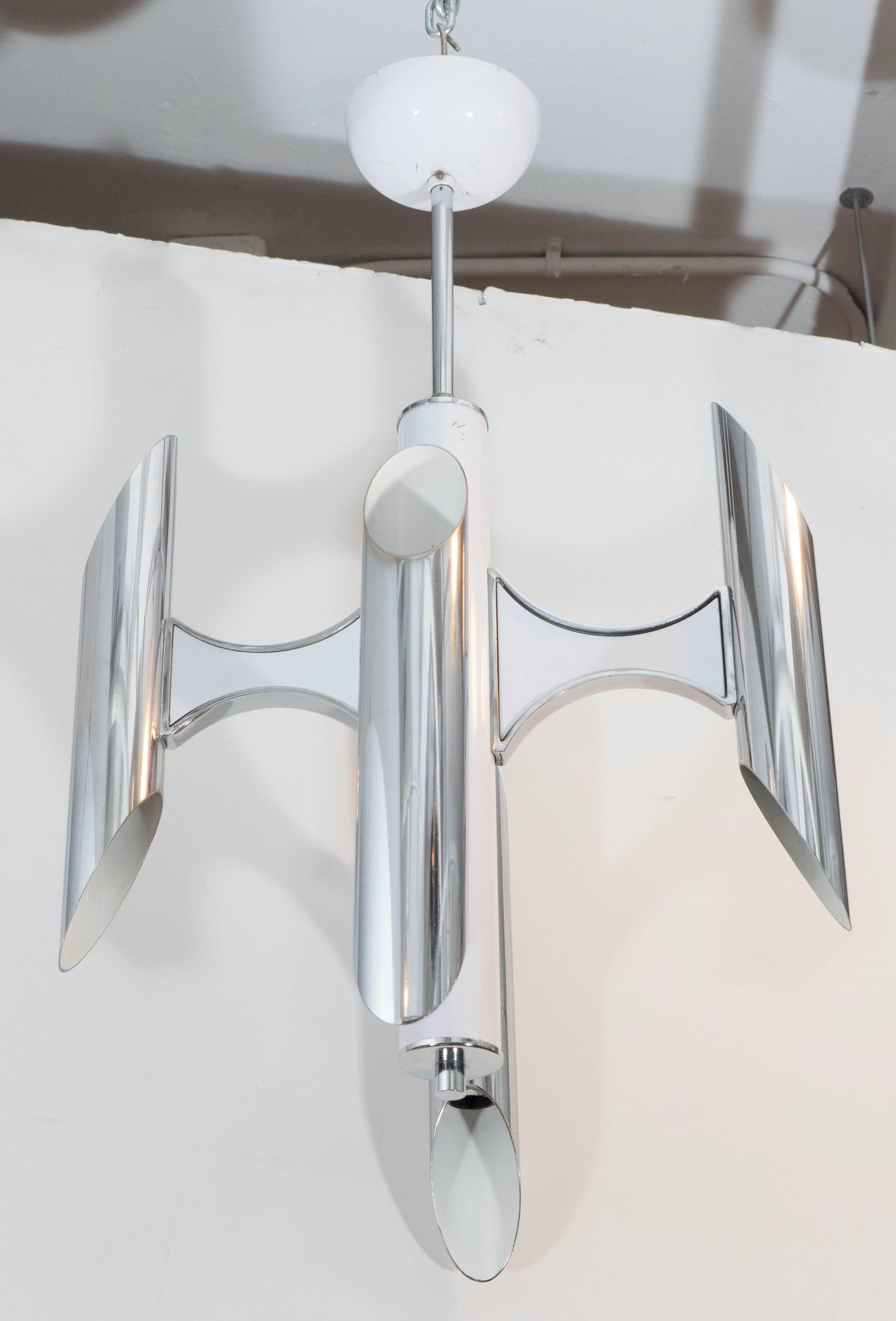 A vintage Italian chandelier in chrome and white enamel, designed in the highly modern style by Gaetano Sciolari, circa 1960s, including four buttress arms, each supporting a two-light tubular socket cover, affixed to a central cylindrical nucleus