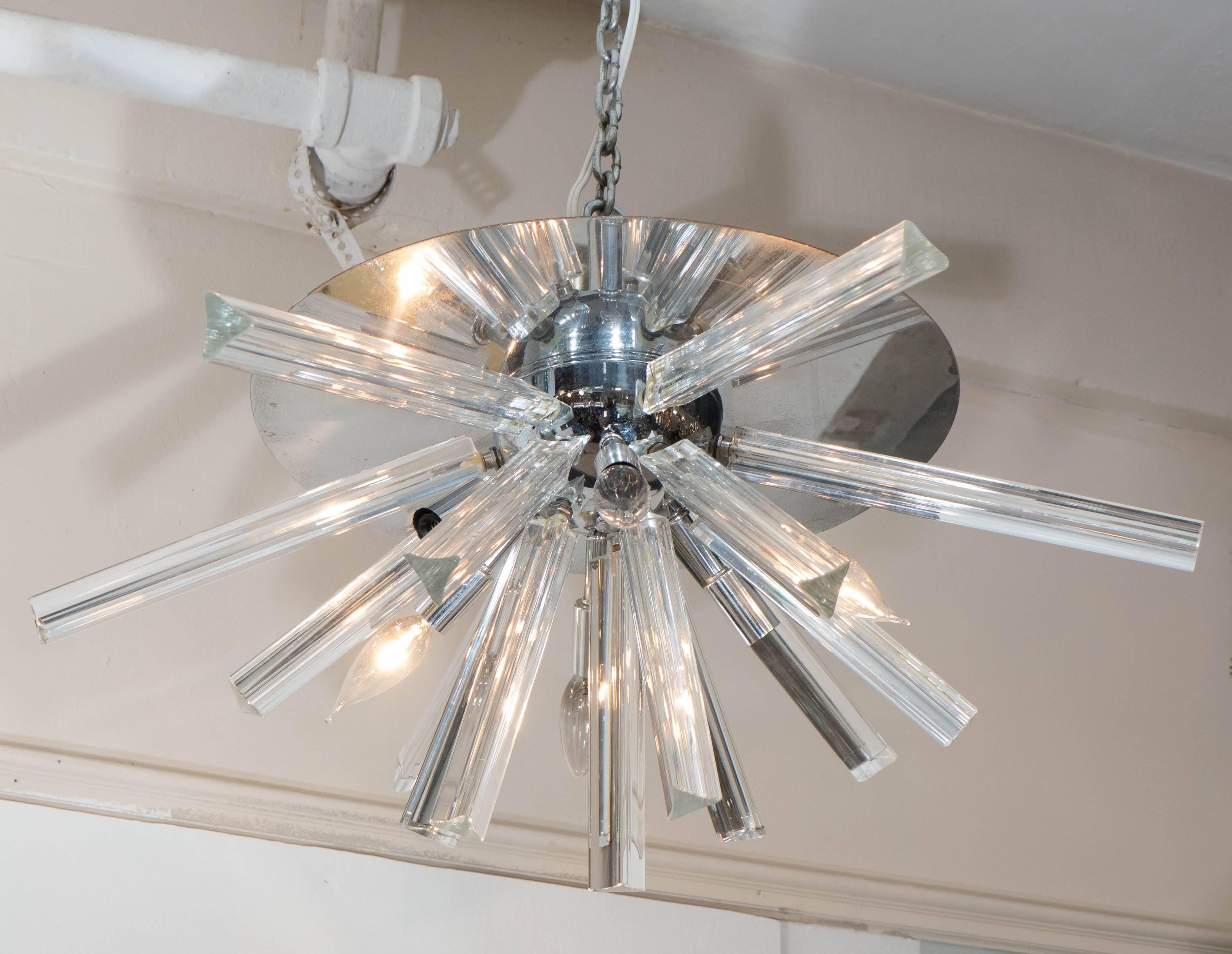 An Italian flush mount Sputnik chandelier, by Venini for Camer, produced circa 1970s, with six sockets and Murano glass triedri prisms extending from a dome form nucleus, affixed to a circular, highly reflective ceiling plate in polished chrome.