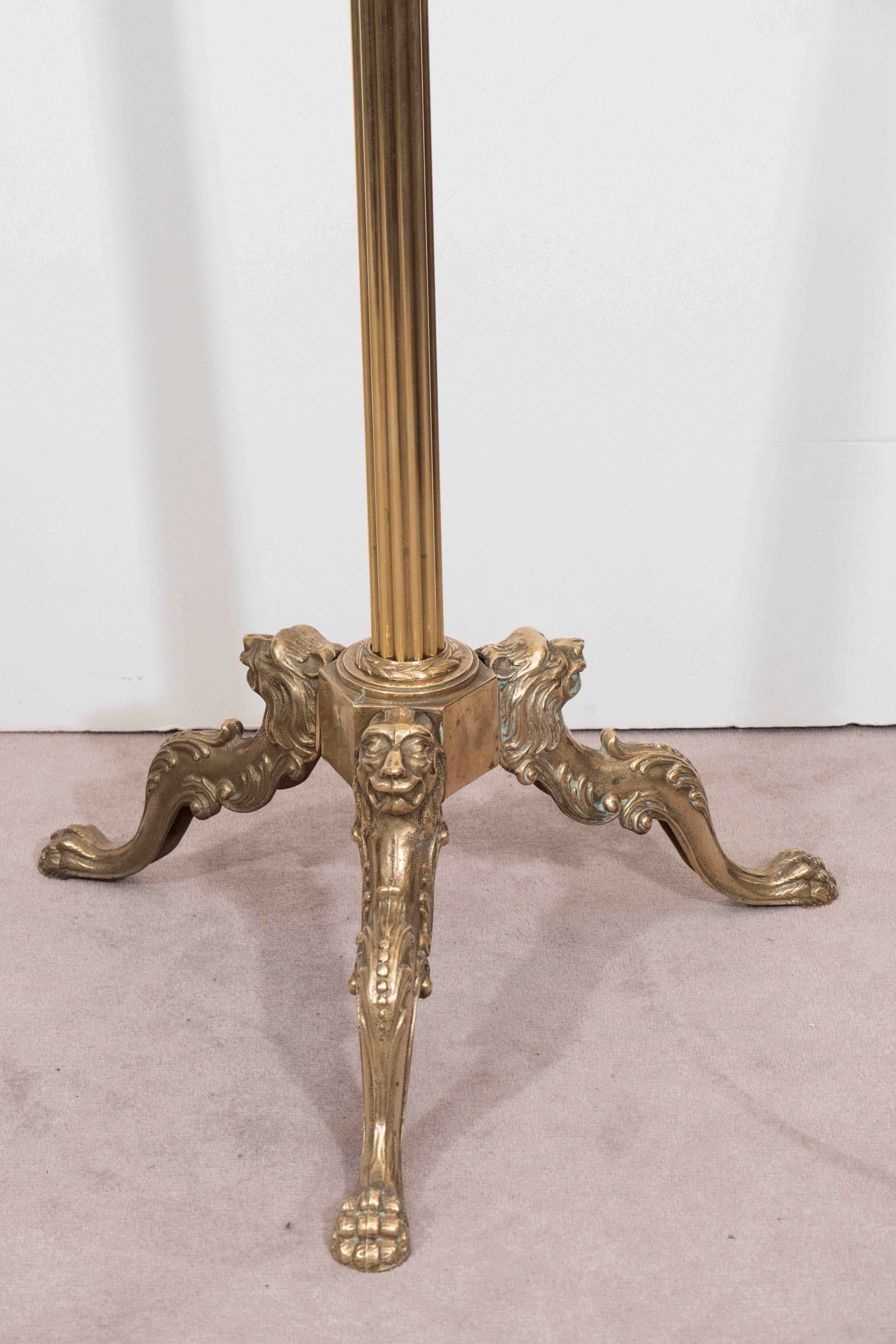 An Italian gentlemen's brass valet, produced circa 1960s, with open rocaille handle as finial, surmounting a wood hanger with shell shaped coin holder, above a reeded stem on scroll tripod legs, detailed with lion heads and terminating in paw feet.