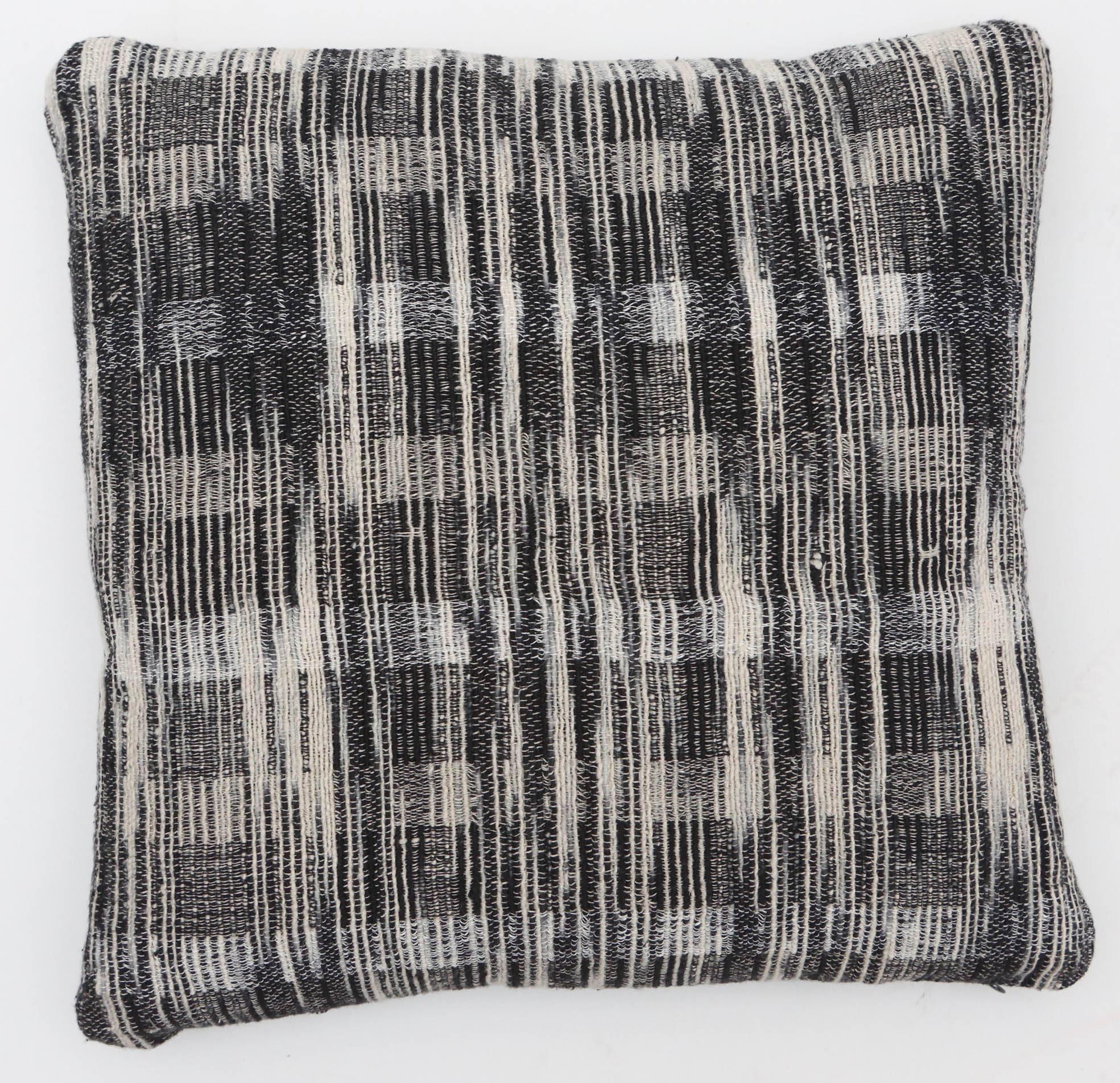 A contemporary line of pillows, throws, bedcovers and yardage hand woven in India on antique Jacquard looms. Handspun wool, cotton, linen, and raw silk give the textiles an appealing uneven quality.

This linen and raw tussar silk pillow has a