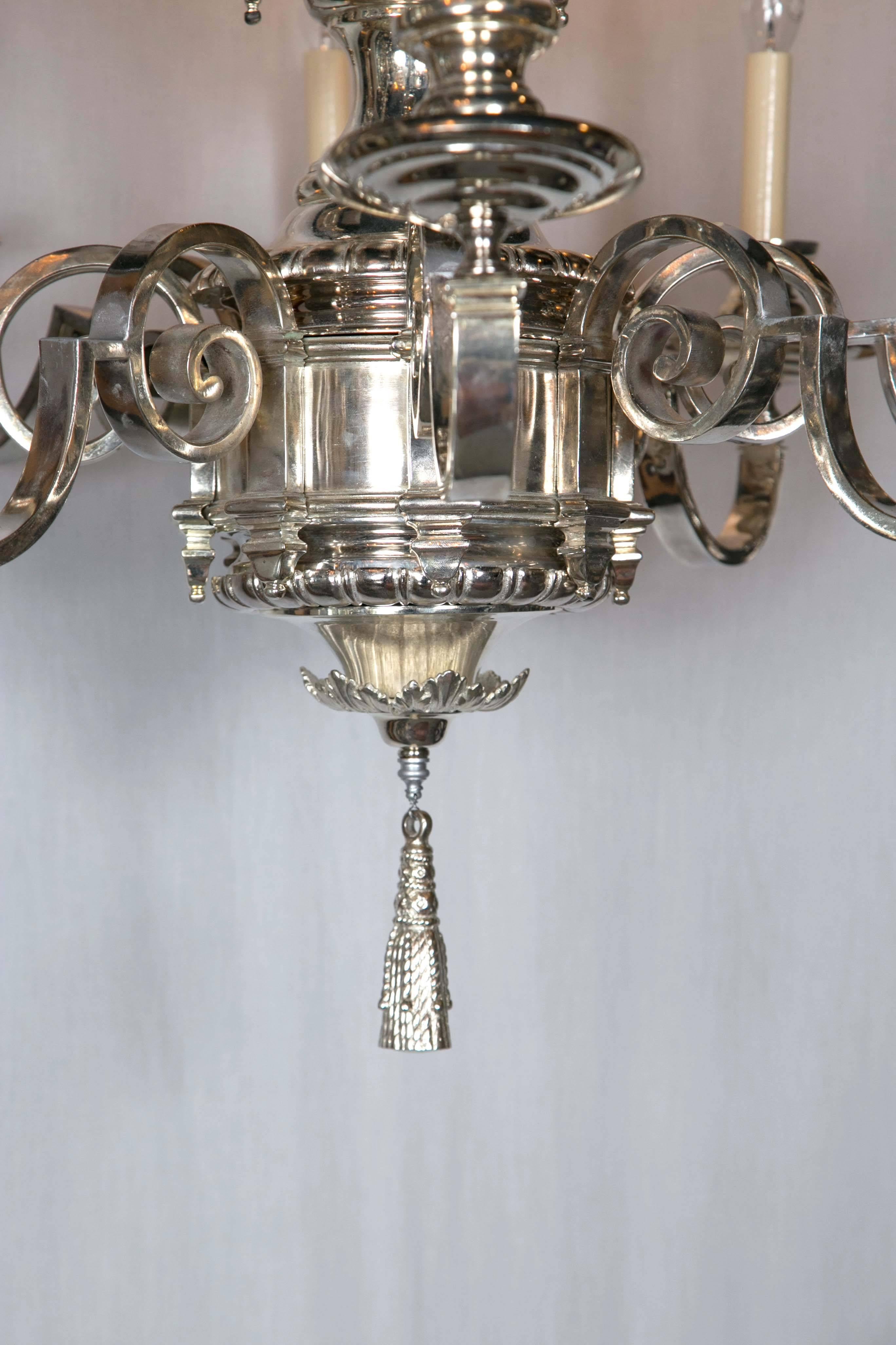 Beautiful silver plated twelve-light chandelier with cherubs at top, neoclassical style Caldwell. Two available priced per fixture.