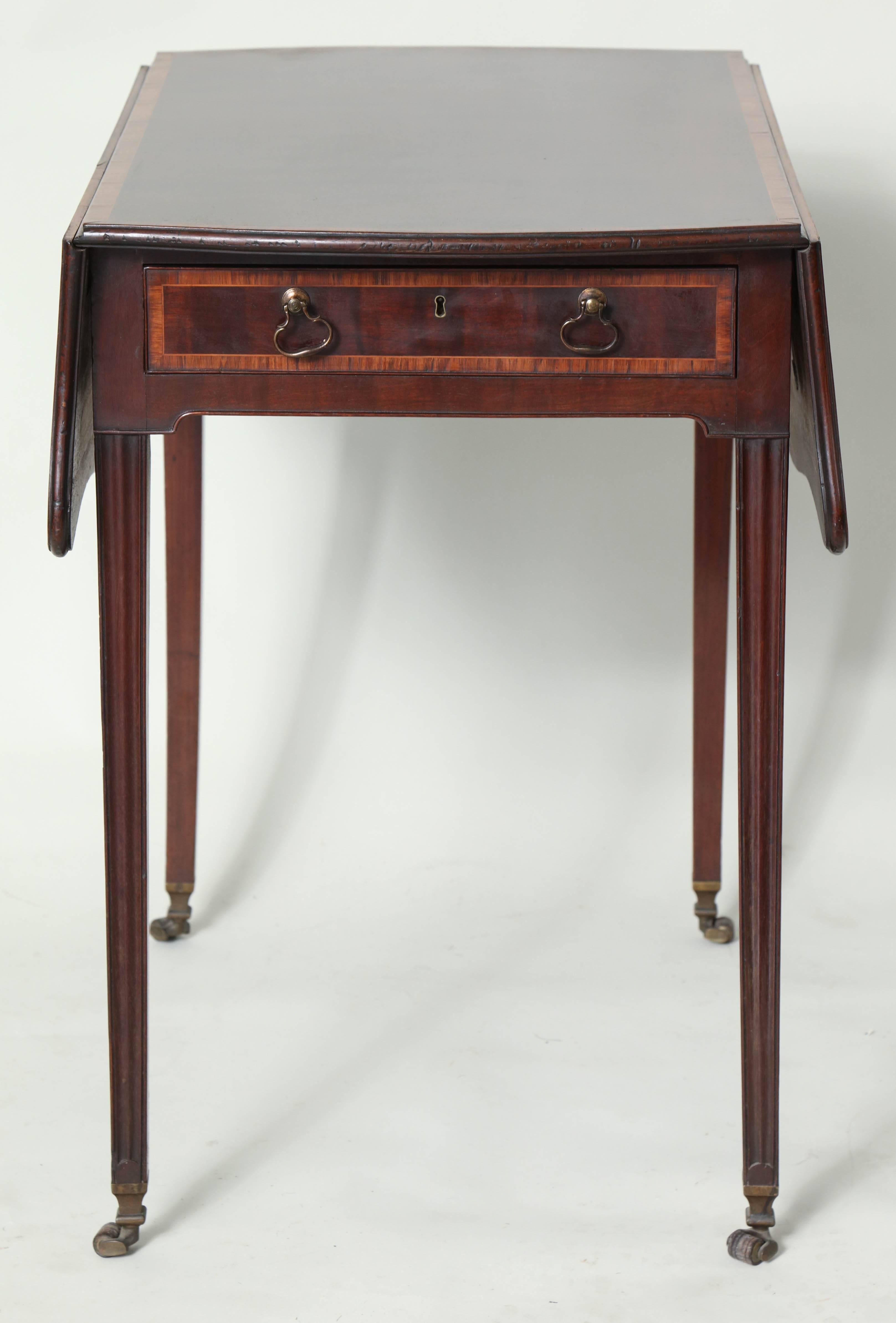 Very fine George III plum pudding mahogany pembroke table with tulipwood banded top, having beaded edge, the shaped leaves over tulipwood banded drawer with original brass pulls on taped legs with cupid bow fluting, the feet with original shaped box