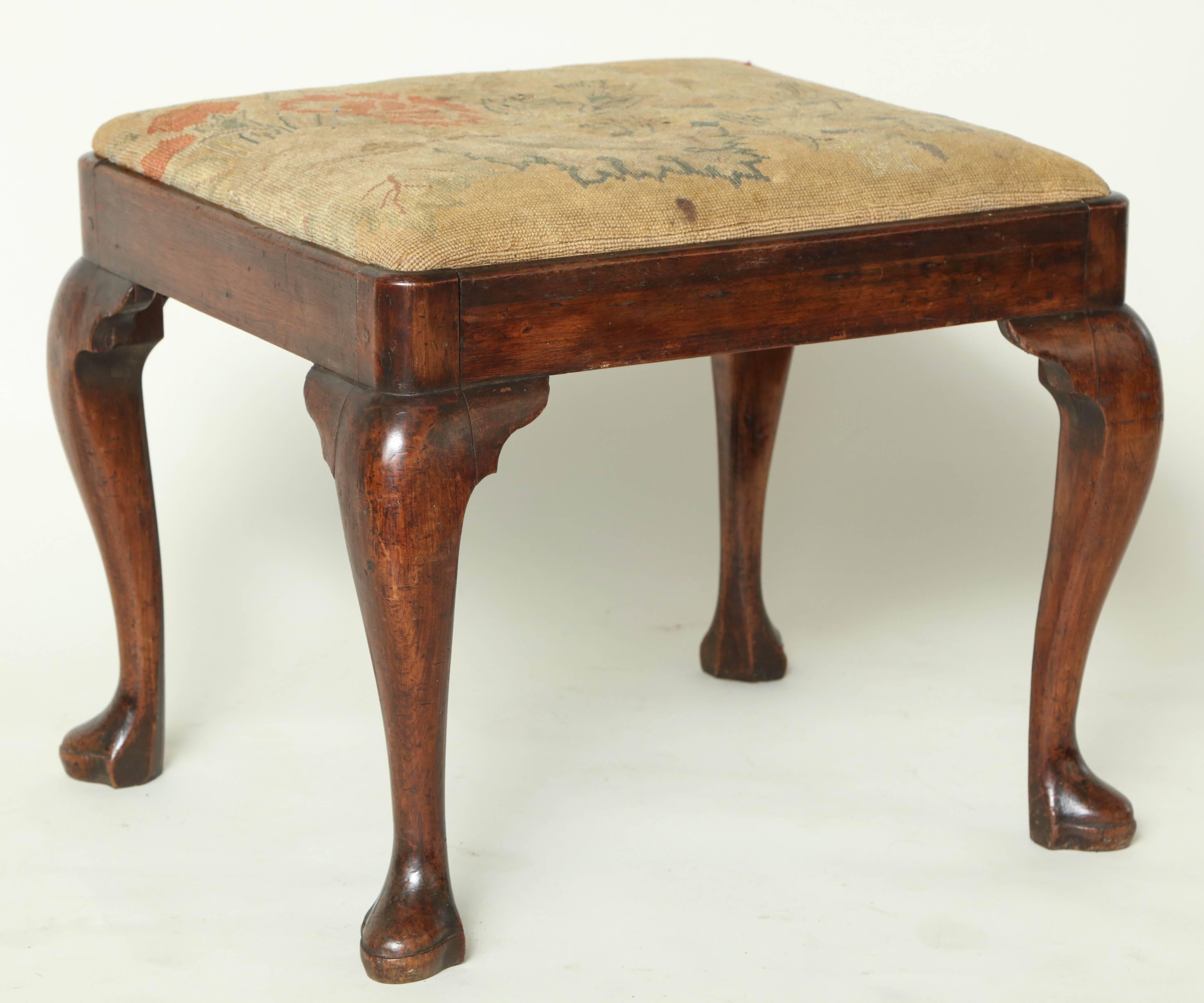 Good 18th century George II walnut stool, with upholstered slip seat, the apron with slightly molded top edge, standing on cabriole legs with shaped corner brackets and standing on triffid feet, the whole with good rich color.