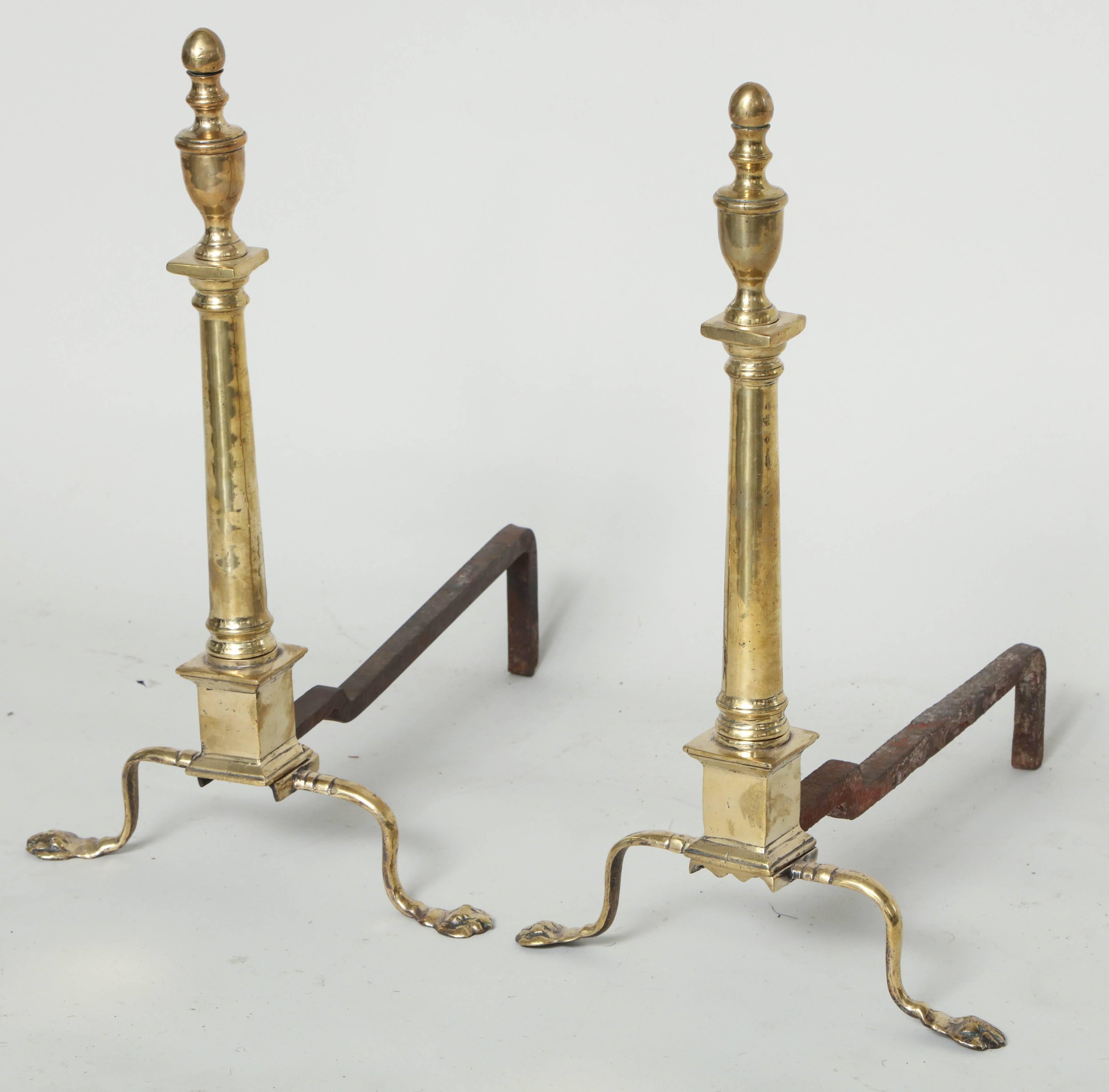Good pair of late 19th century brass neoclassical andirons, the urn finial over column shaft standing on shaped legs ending in flattened paw feet.