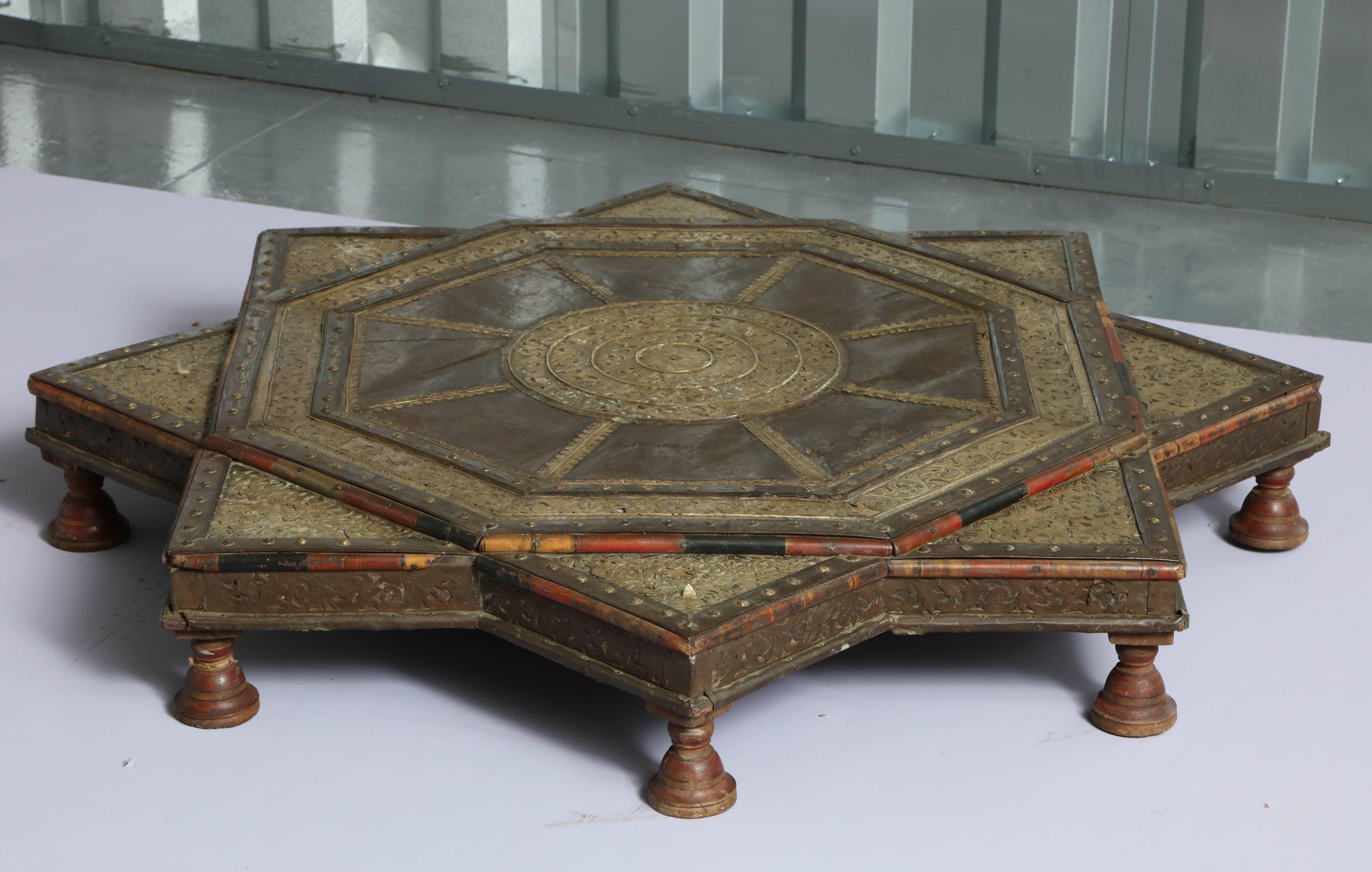 Most unusual Kashmiri low table in the form of an octagonal star or octagram, the patinated steel top bound with filigree brass trimming, having polychrome bamboo edging, brass and iron stud work and standing on low turned painted feet, the whole