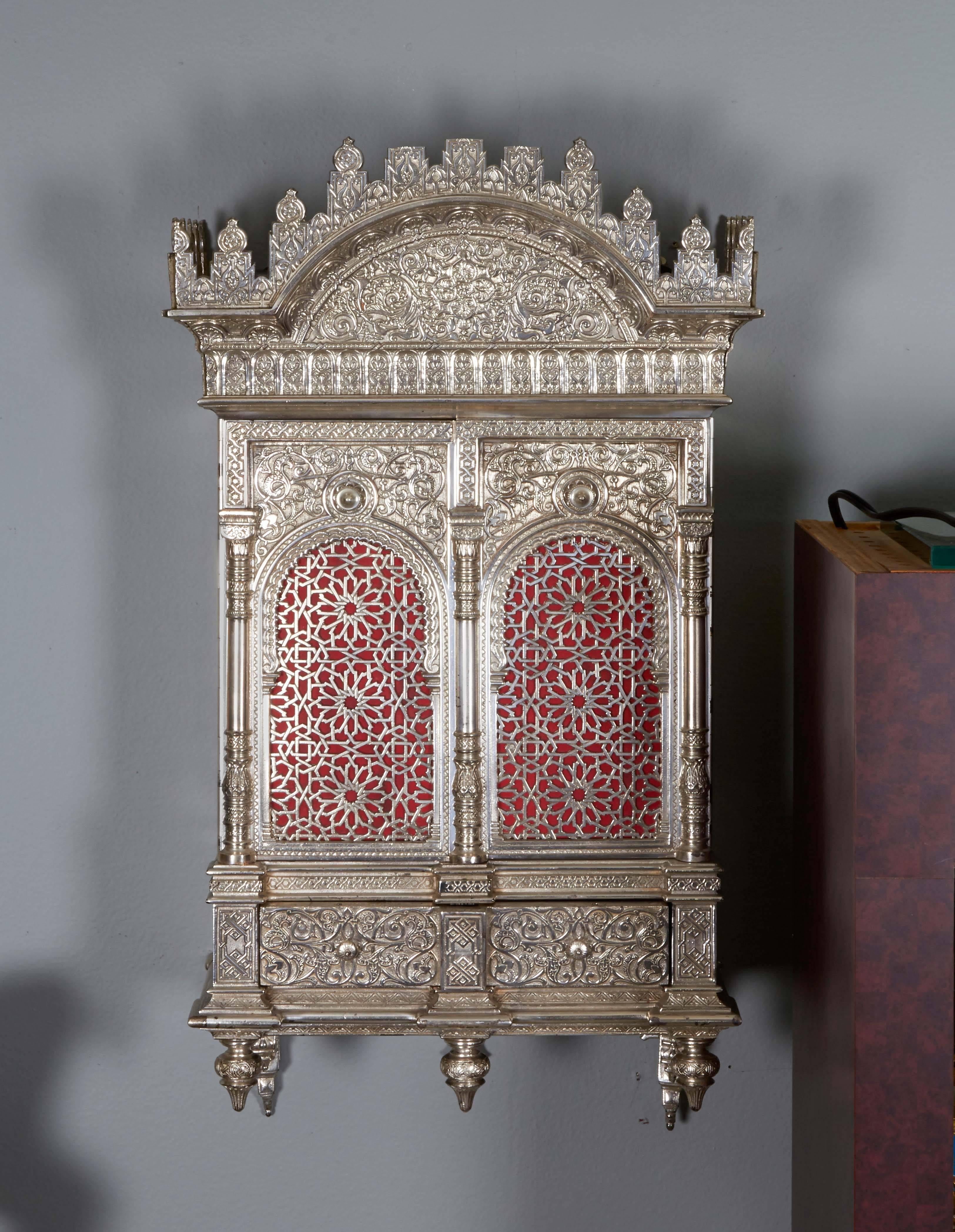 A magnificent and rare silvered bronze (electroplate) Alhambra wall cabinet / Torah Ark in the Moorish / Nasrid style.

Attributed to Rafael Contreras.

Probably France or Germany, circa 1880.

Of rectangular form with crest and pendant finials to