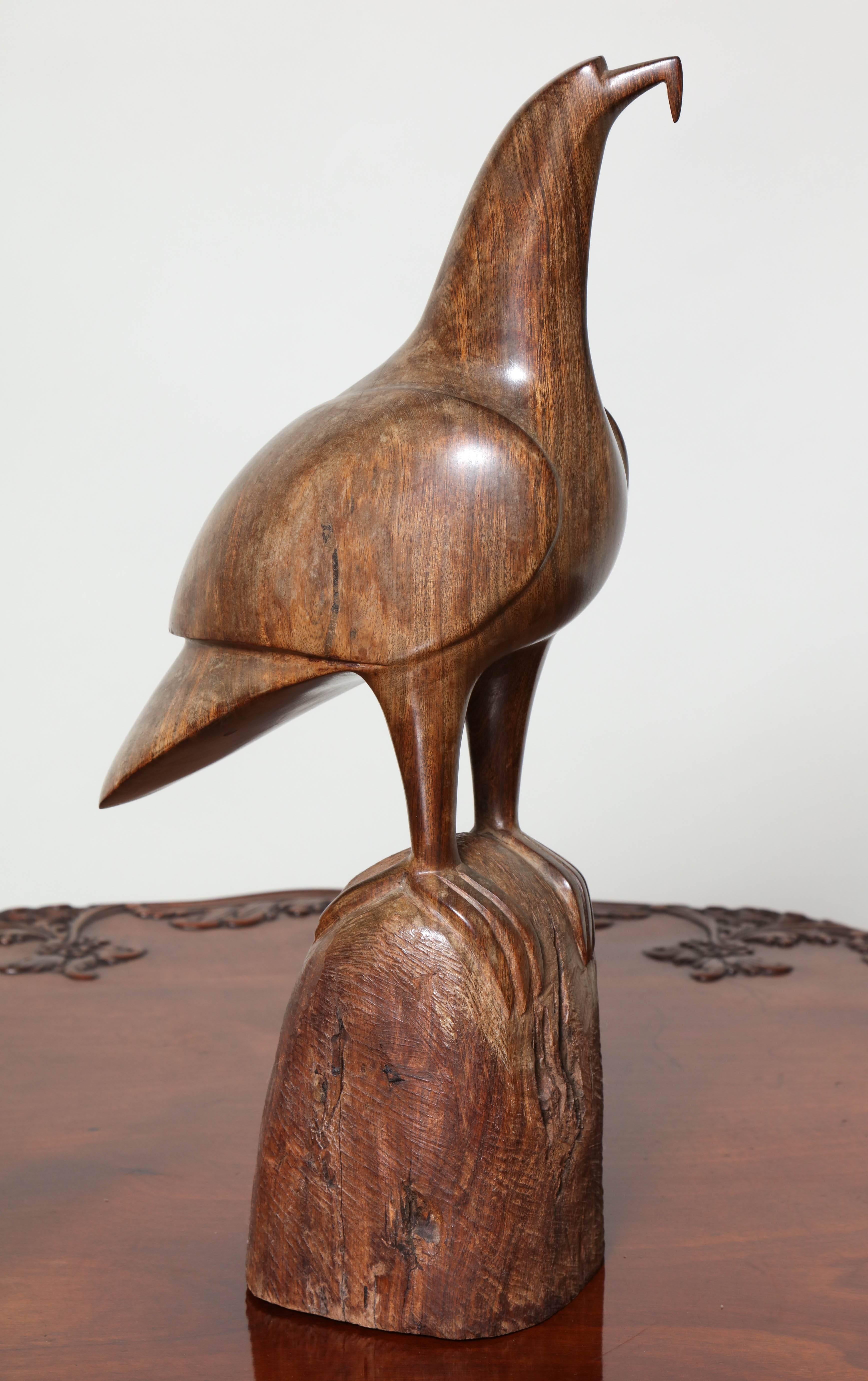 Finely carved Koa wood seabird, probably a frigate bird or shearwater, crafted from vividly grained and dense timber, the highly burnished surface of the bird standing out in contrast from the roughhewn and rasped stump on which it stands.
Both