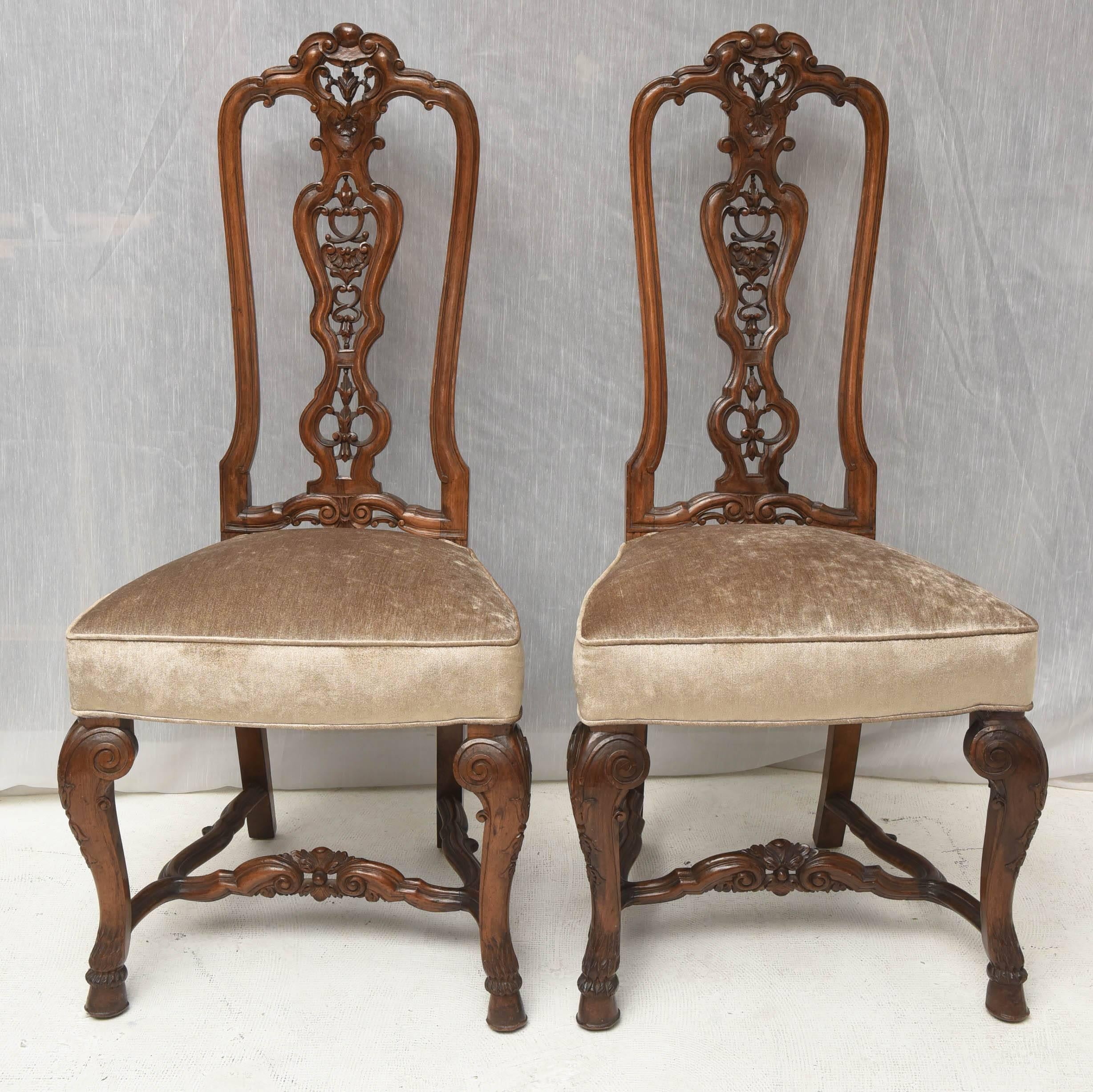 19th century pair of English walnut side chairs,
solid walnut carved in a very artistic craftsmanship.
Tight frame, recently reupholstered in a light velvet fabric.
Elegant design. Georgian style.