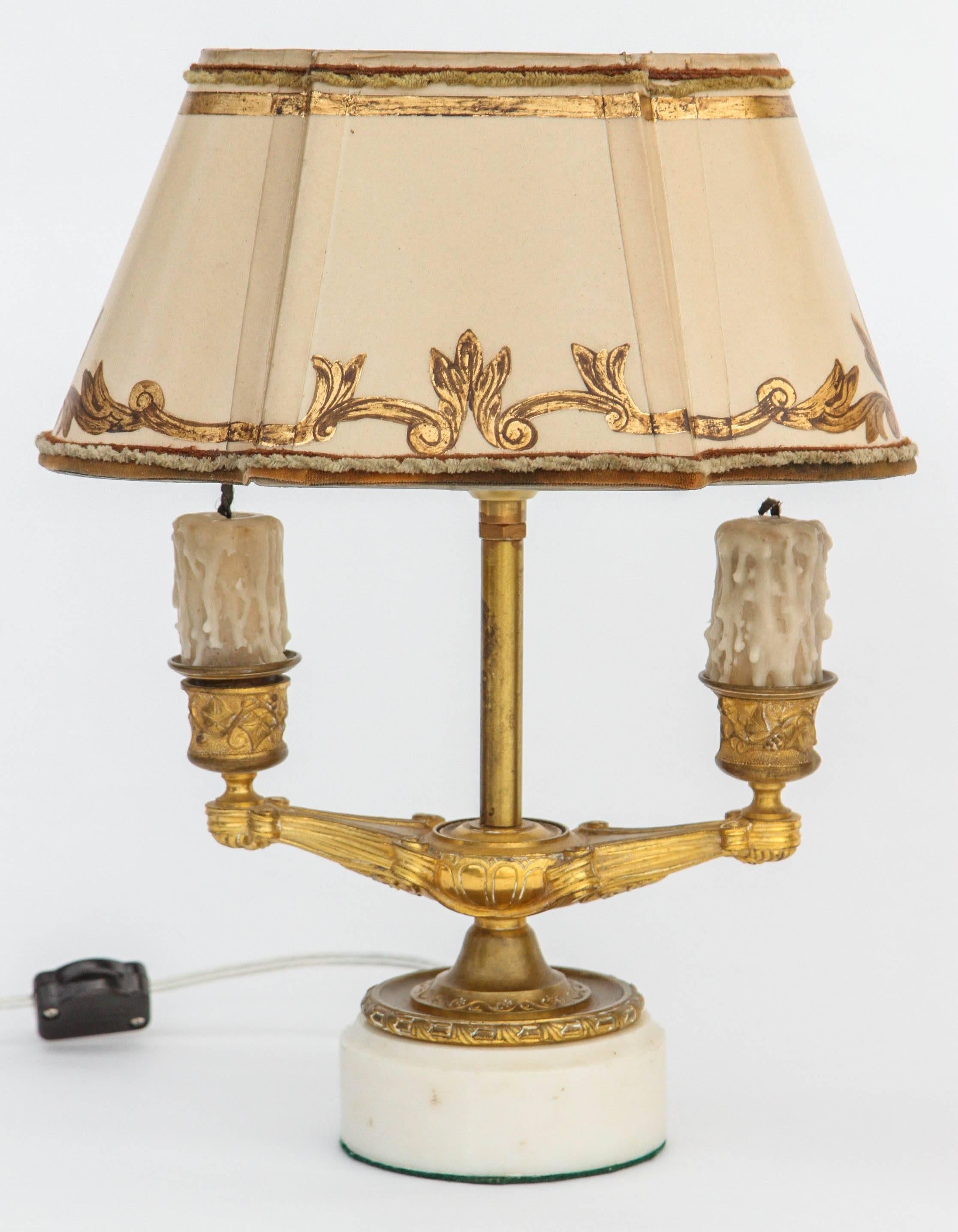 Pair of 19th century French doré bronze candles converted to lamps with marble bases. The shades are included and are handmade of Parchment Paper. They are hand gilded and decorated. The lamps have been newly wired.