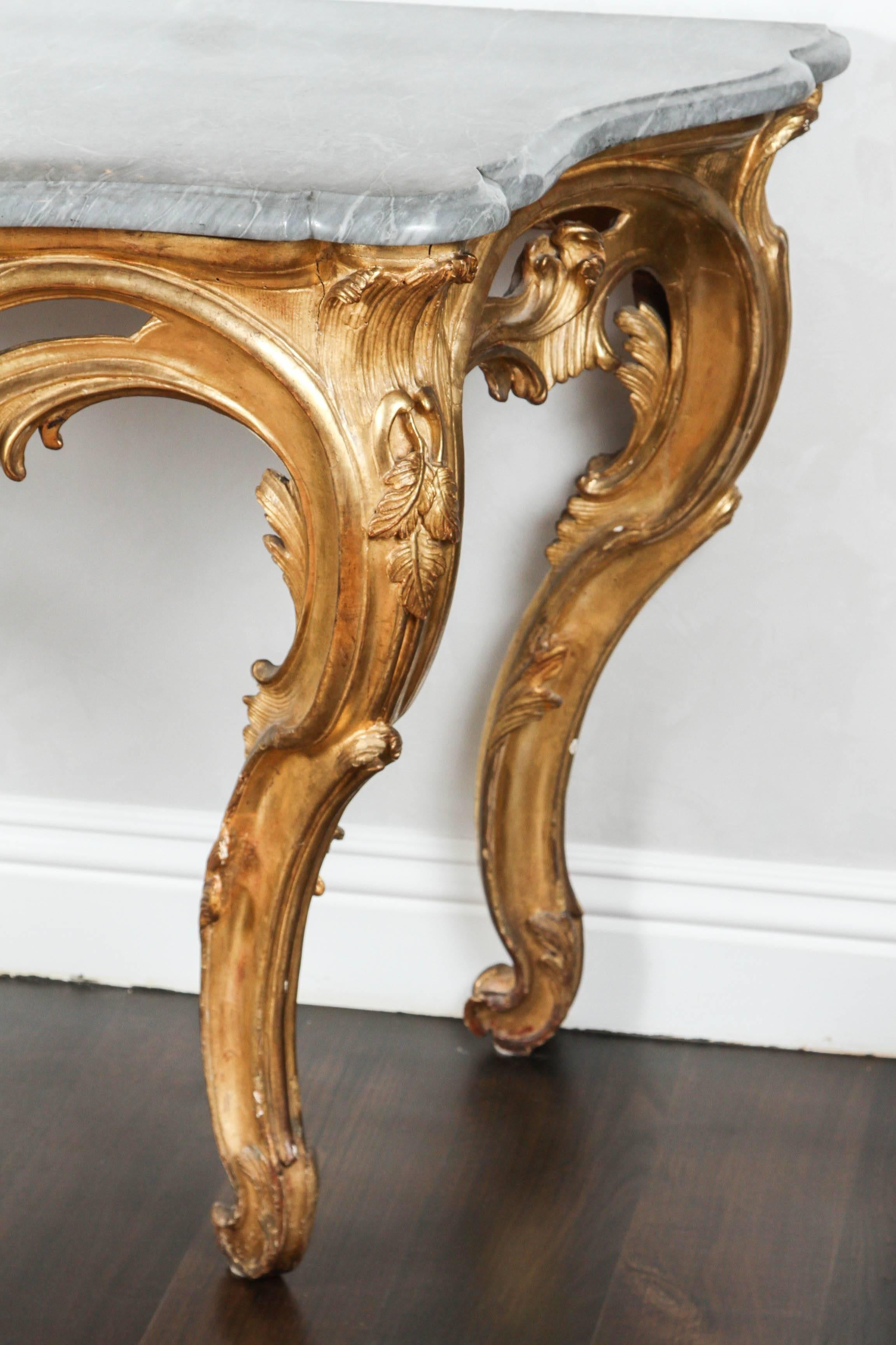 Late 18th-19th century French giltwood console with original gray marble-top and leaf motif.