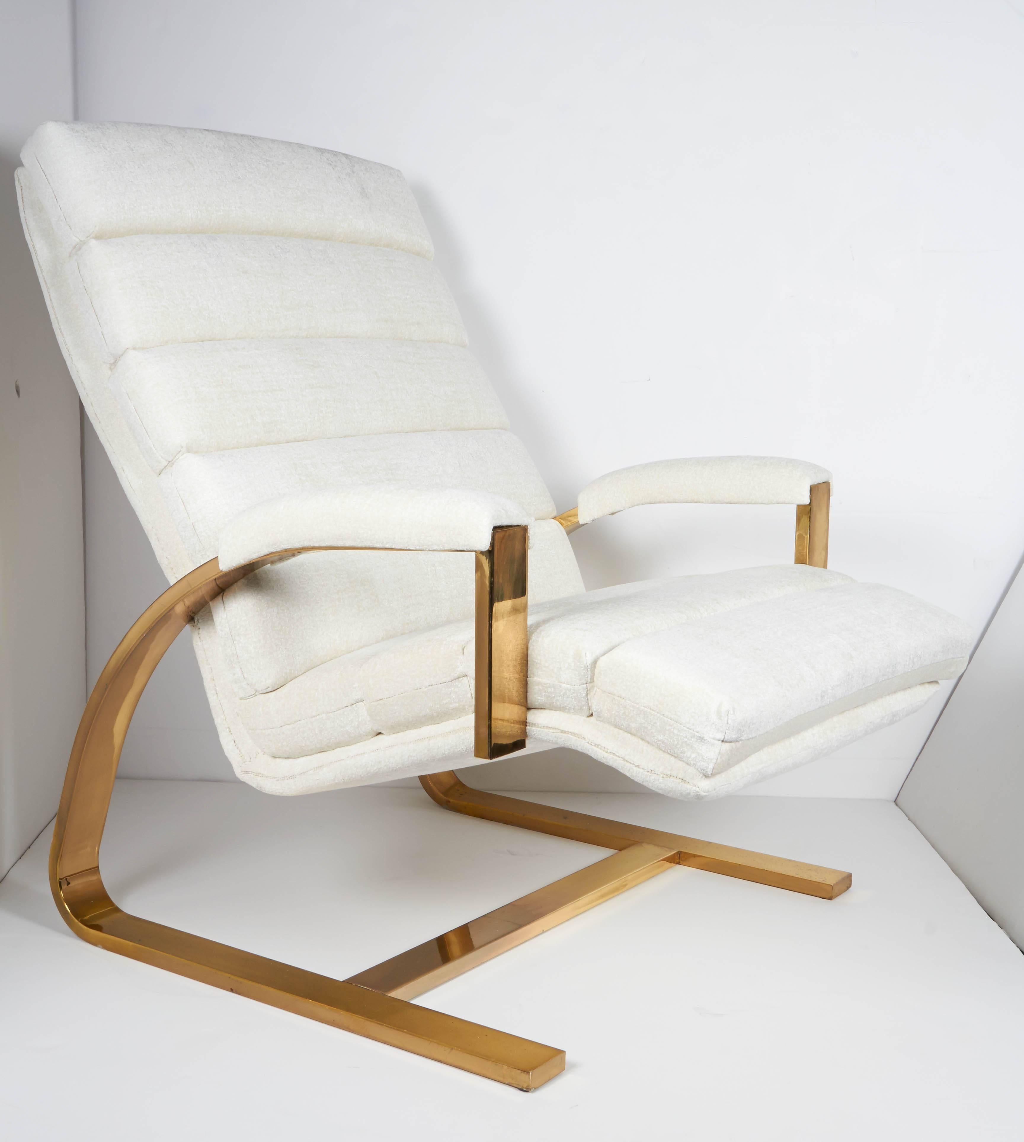 Pair of sexy lounge chairs with ultra modernist profiles. The chairs feature unique cantilevered frames with arched designs in a highly polished brass. Newly upholstered in a nubby crème chenille, featuring mod channel tufting along back and seat,
