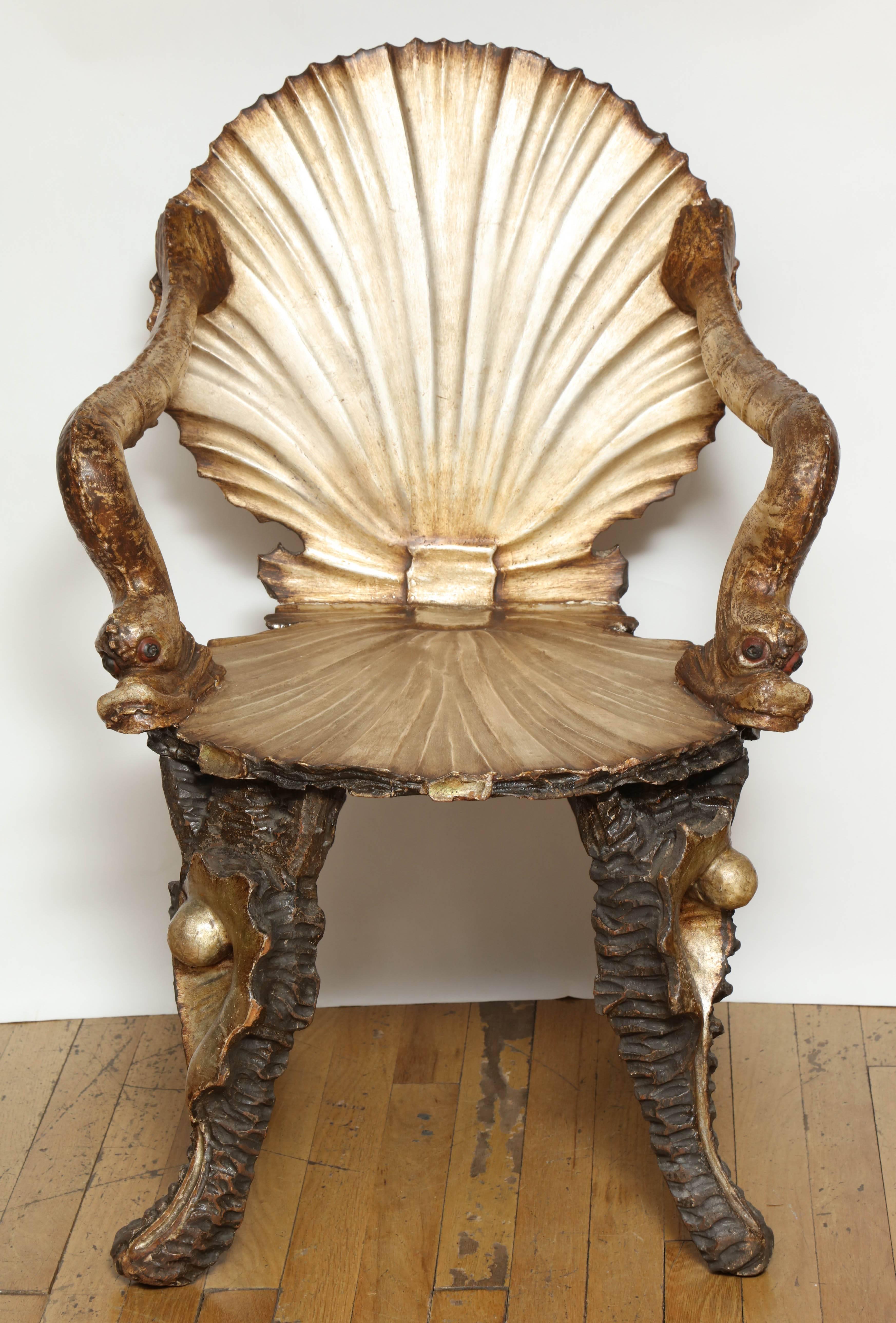 A pair of carved and silvered wood Venetian Baroque-style shell chairs, the seat and back in the form of stylized scallop shells, joined by dolphin shaped arms above four shell form legs. The frames with original silver and white gold finish, circa