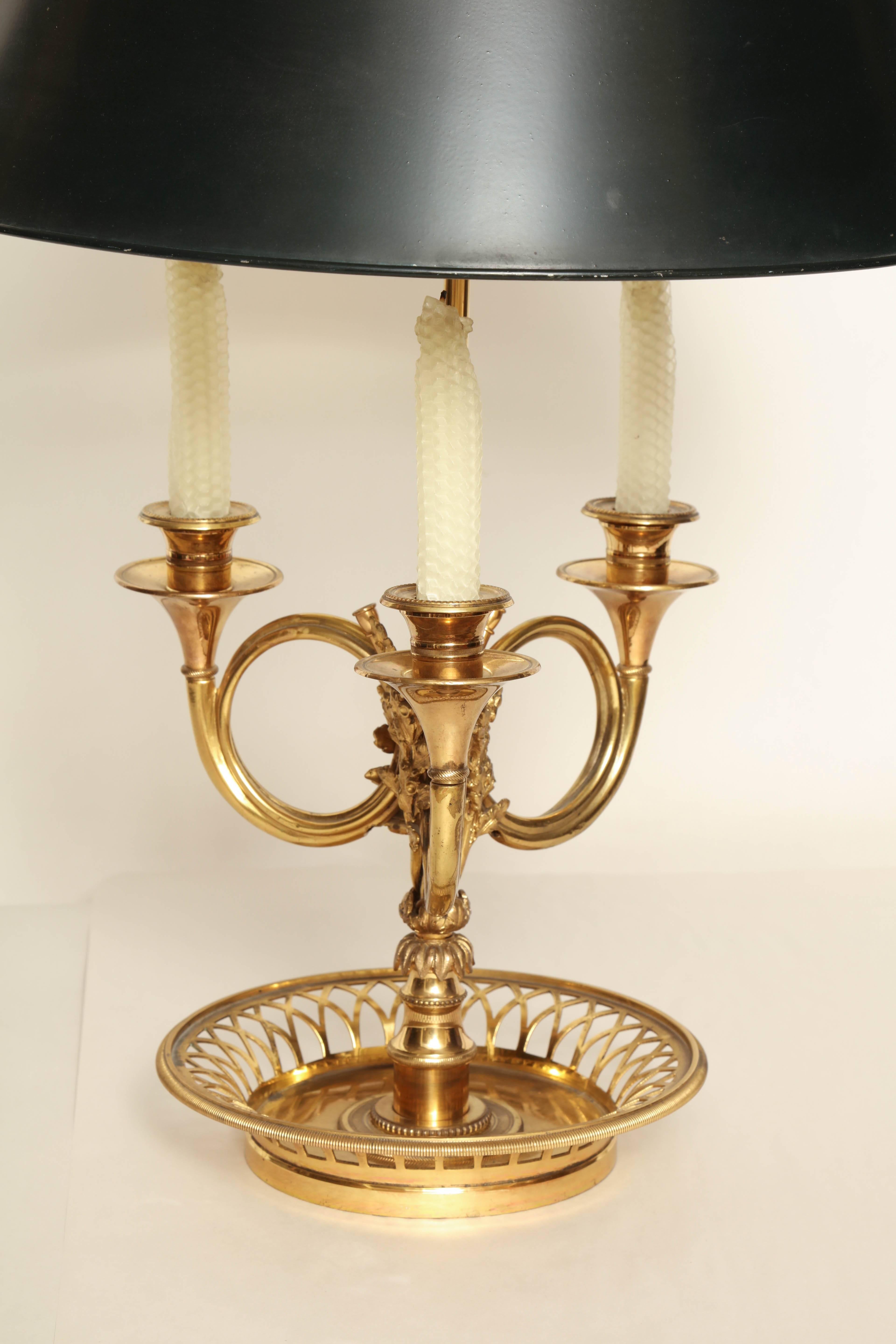 A French Louis XVI Style brass Bouillotte 2-light table lamp, with 3 candles each supported by a curled Horn-shaped arm, and emanating from a tiered stem issuing from a pierced stem base, and decorated with laurel leaves. Adjustable stem supports a