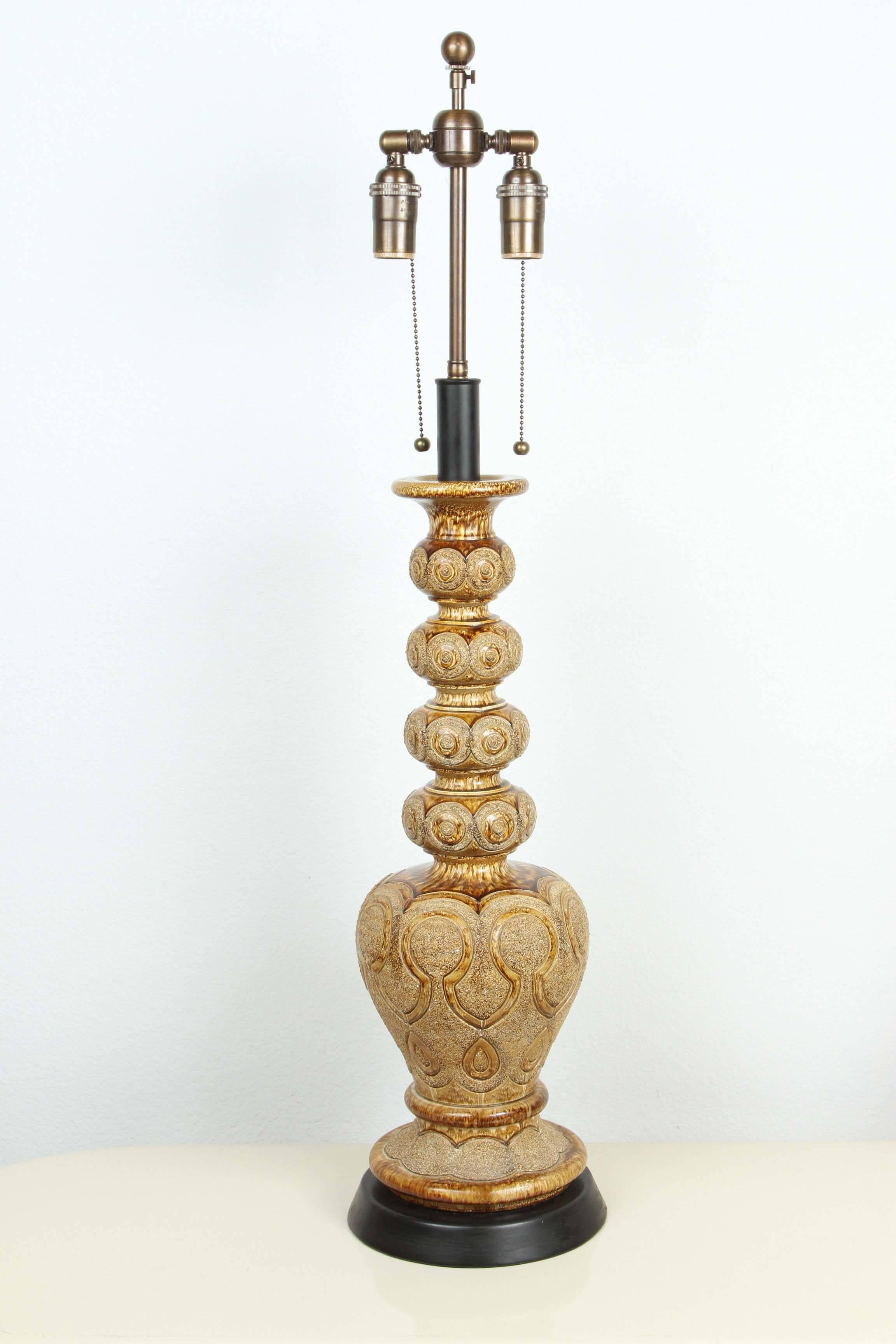 Pair of exotic ceramic table lamps with an umber glaze. 
The variations in the patterned surface texture make the glaze appear multicolored.
The lamps have been newly rewired with antique bronze finished double clusters.

 