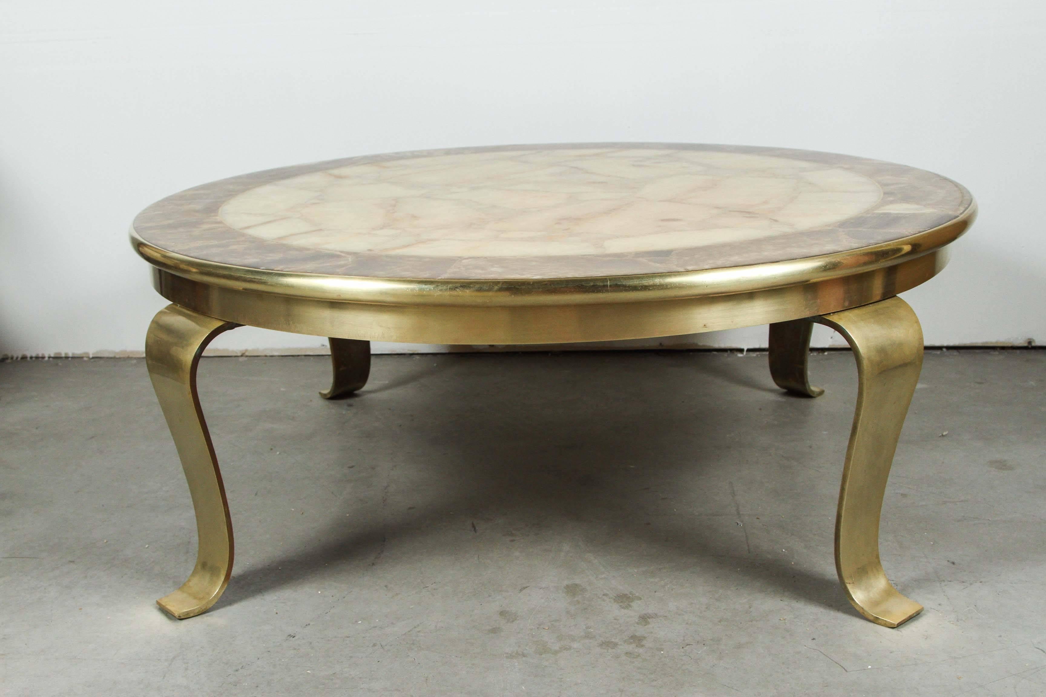 Beautiful brass and onyx table by Robert & Mito Block.
The stunning onyx top has a thick brass edge banding and is mounted on polished brass scrolling legs.