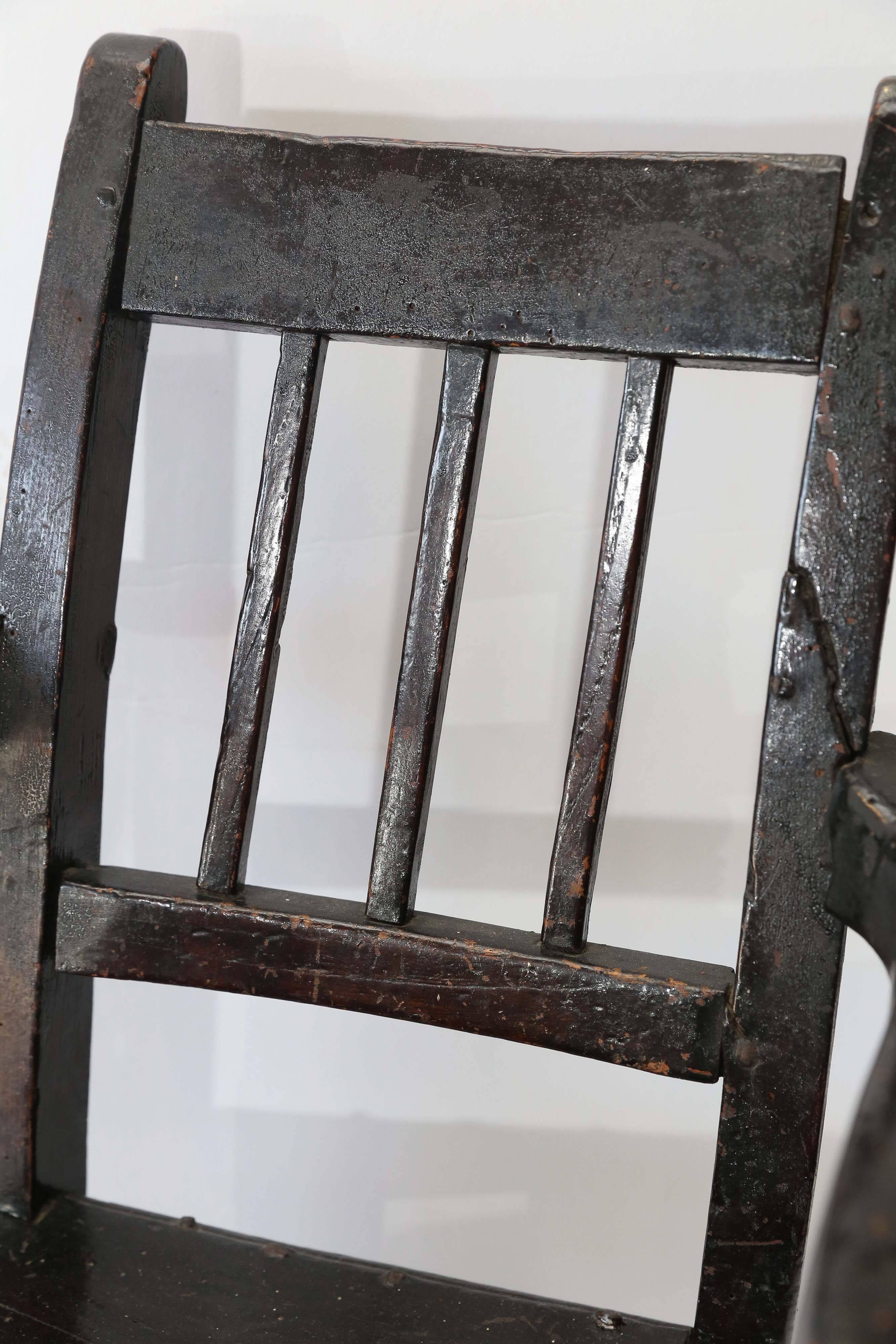 bemalter Kinderstuhl aus dem 19. Jahrhundert mit Reparaturen aus Metall. Detail Drehung der Arme. Charmantes Beispiel für englische Volkskunst.
