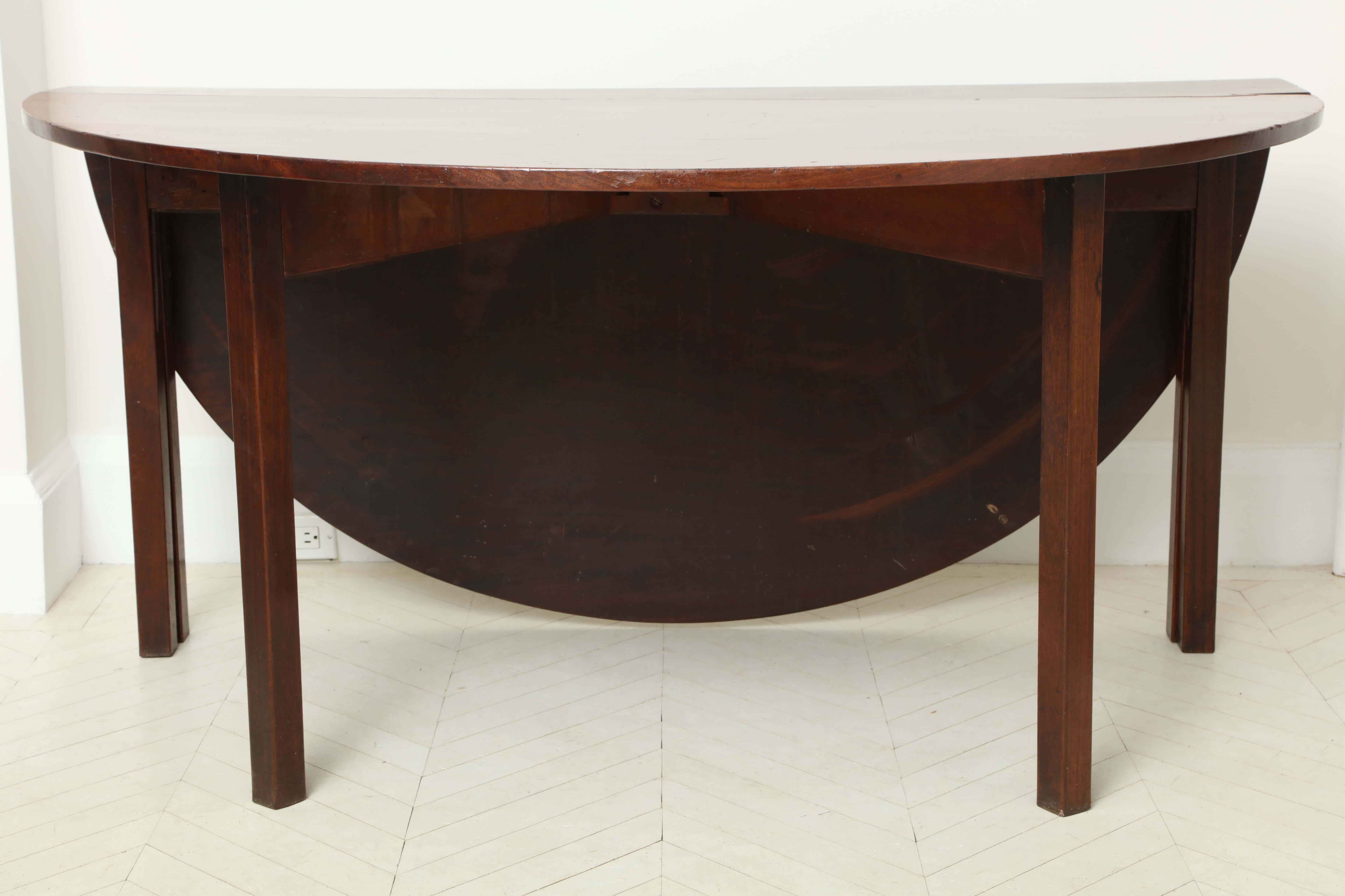 A rare George III mahogany dining table with two enormous oval leaves and square gate-leg supports, circa 1760.