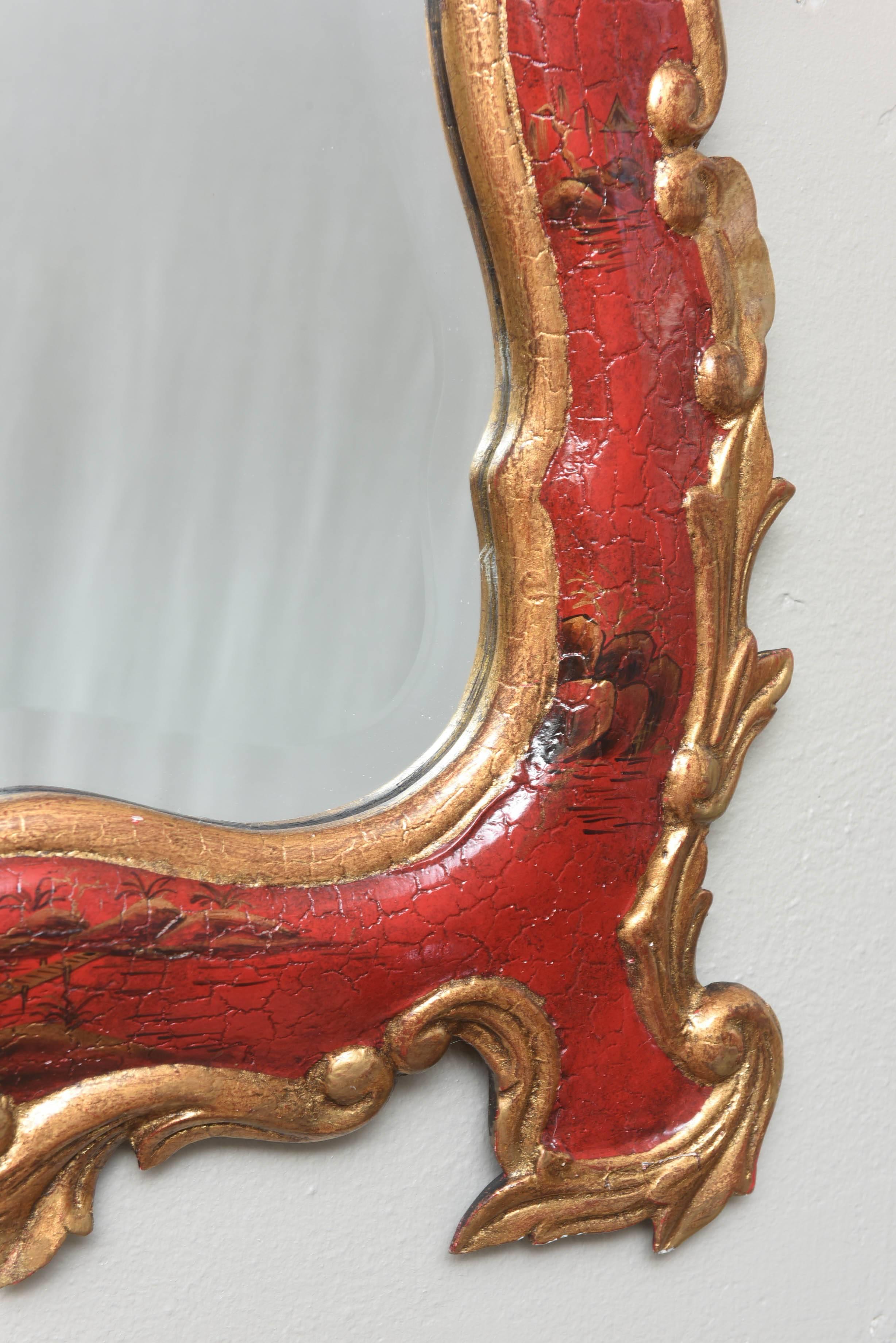 A striking and well proportioned mirror retaining its vibrant red color, gilding and faux finish and hand painting. Timeless Chinoiserie design, always in style and in very nice condition. Please inquire if you need more pictures or information.