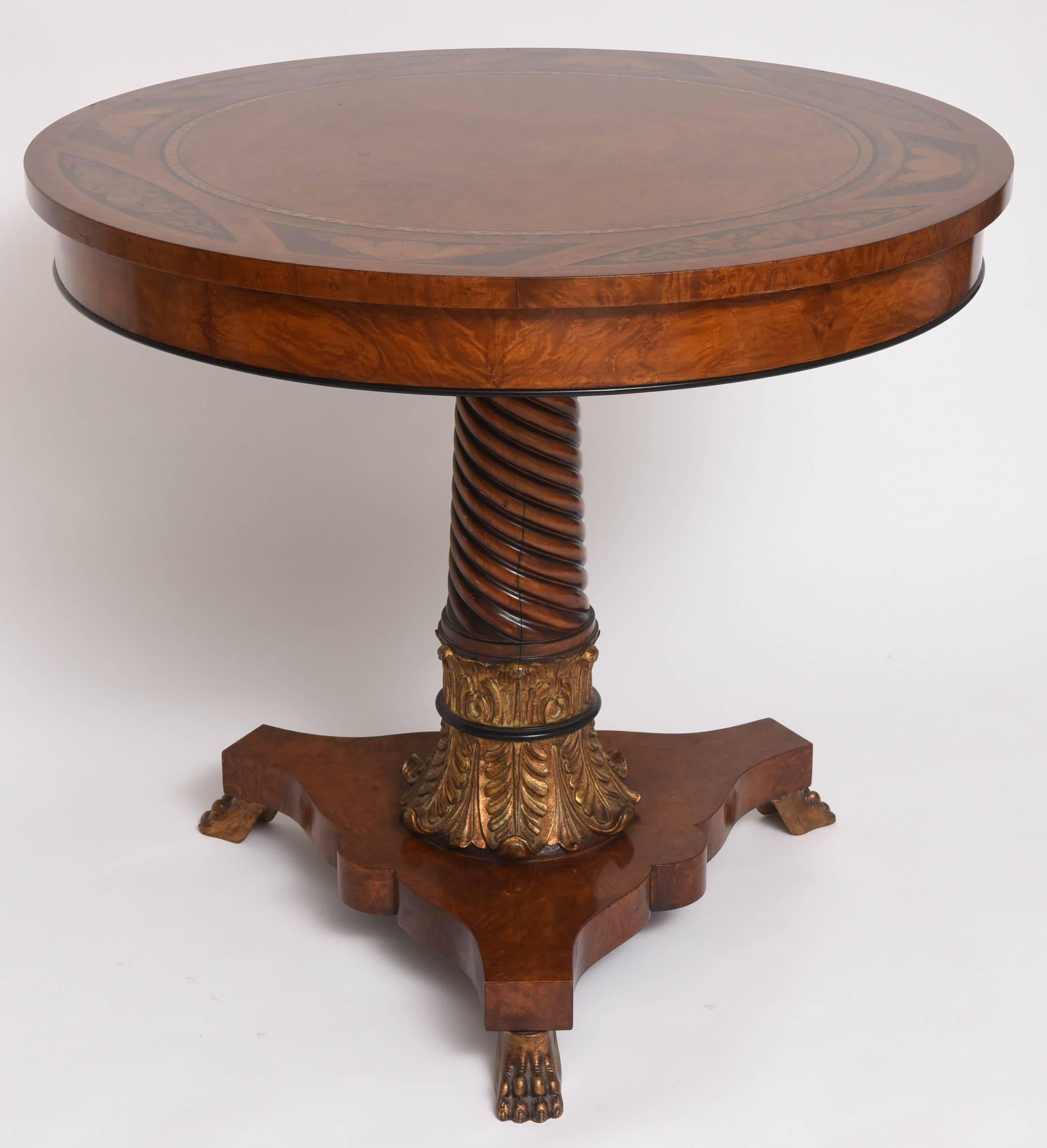 This handsome center table is from the iconic Italian furniture company Rho Mobili D' Epoca. The burled-wood top in inset with a geometric border, floral bouquets, clam shell's and sea-creatures. The spiraling central column is supported with