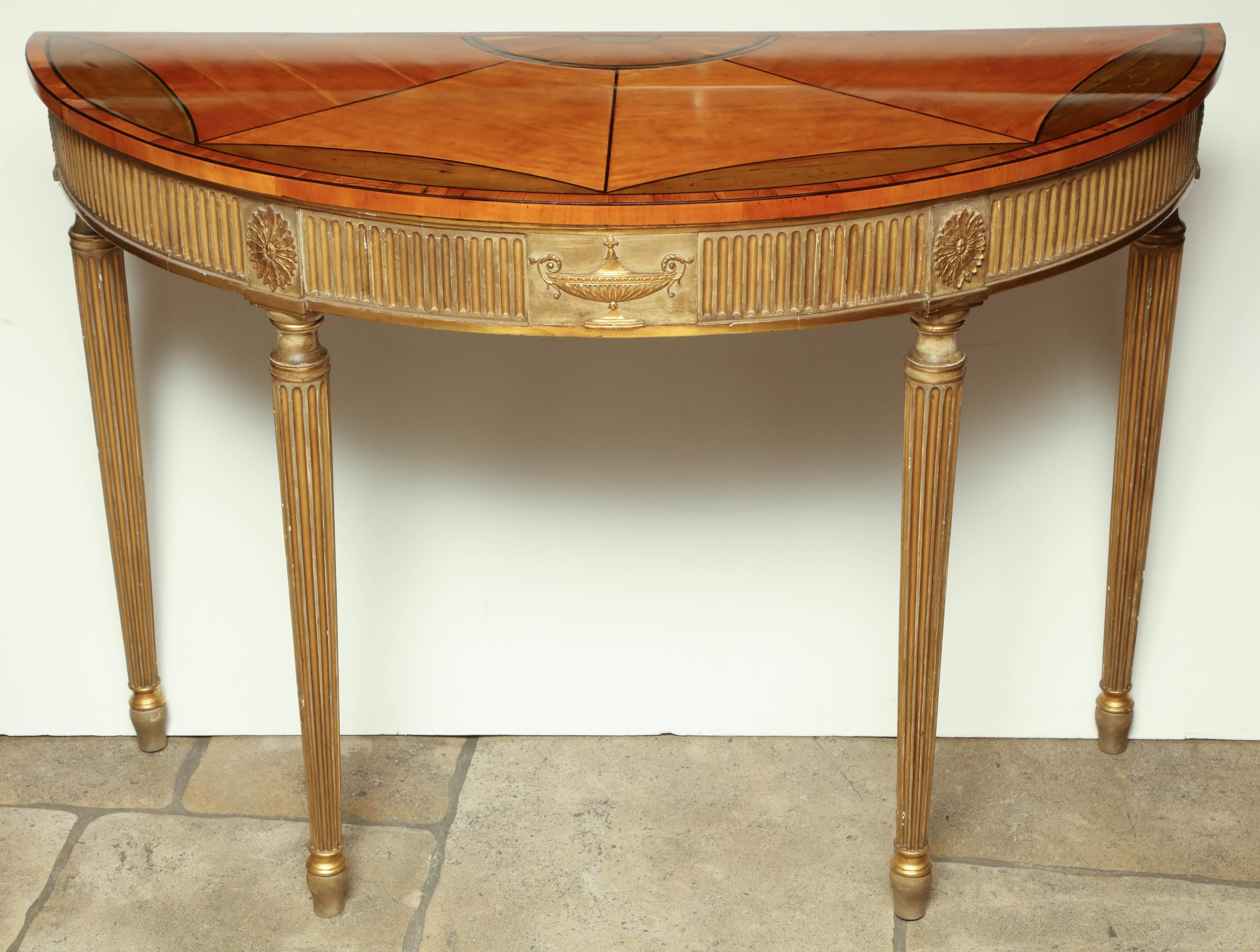 George III (Adam) satinwood and gilt demilune console with fan inlaid top and a fluted and gilt base.