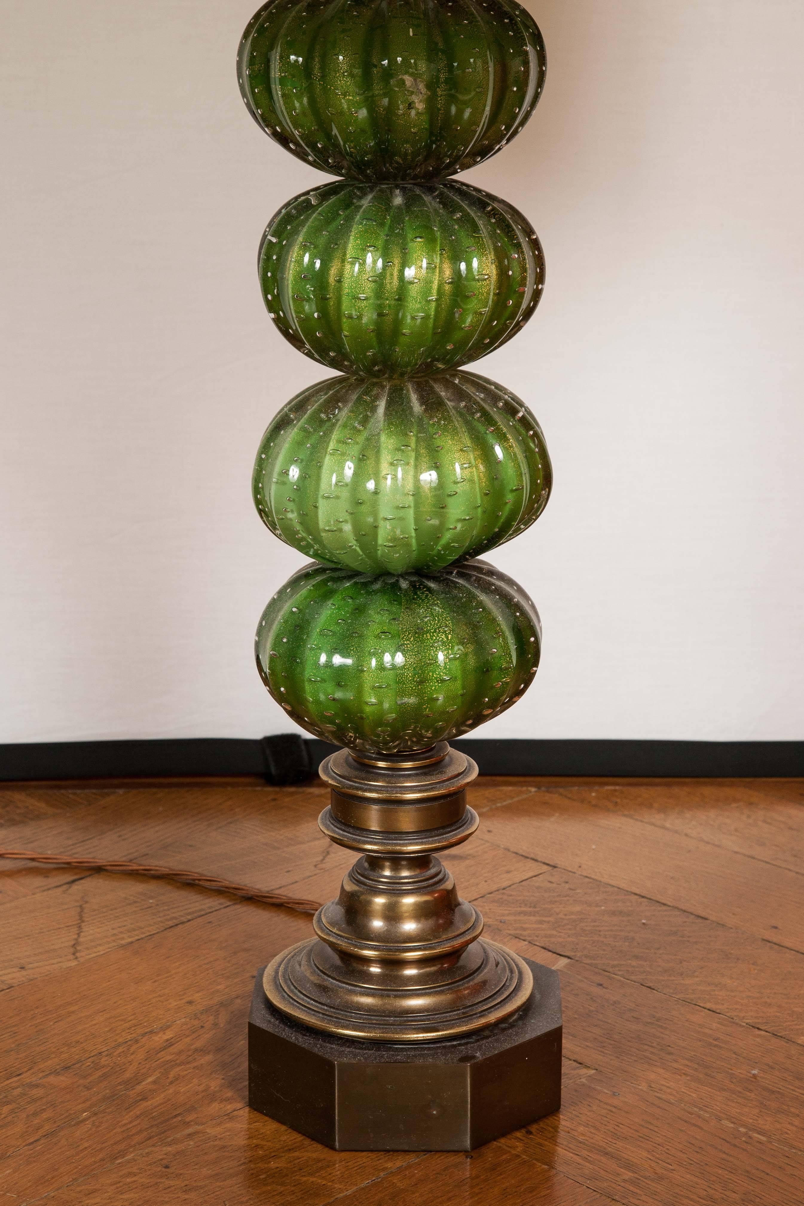 These fun lamp bases in green glass have a stacked and ridged design on a brass and wooden base finished with modern silk shades. 

Measures: Total Height 97cm.

Shade: Height 40cm, Diameter 50cm.