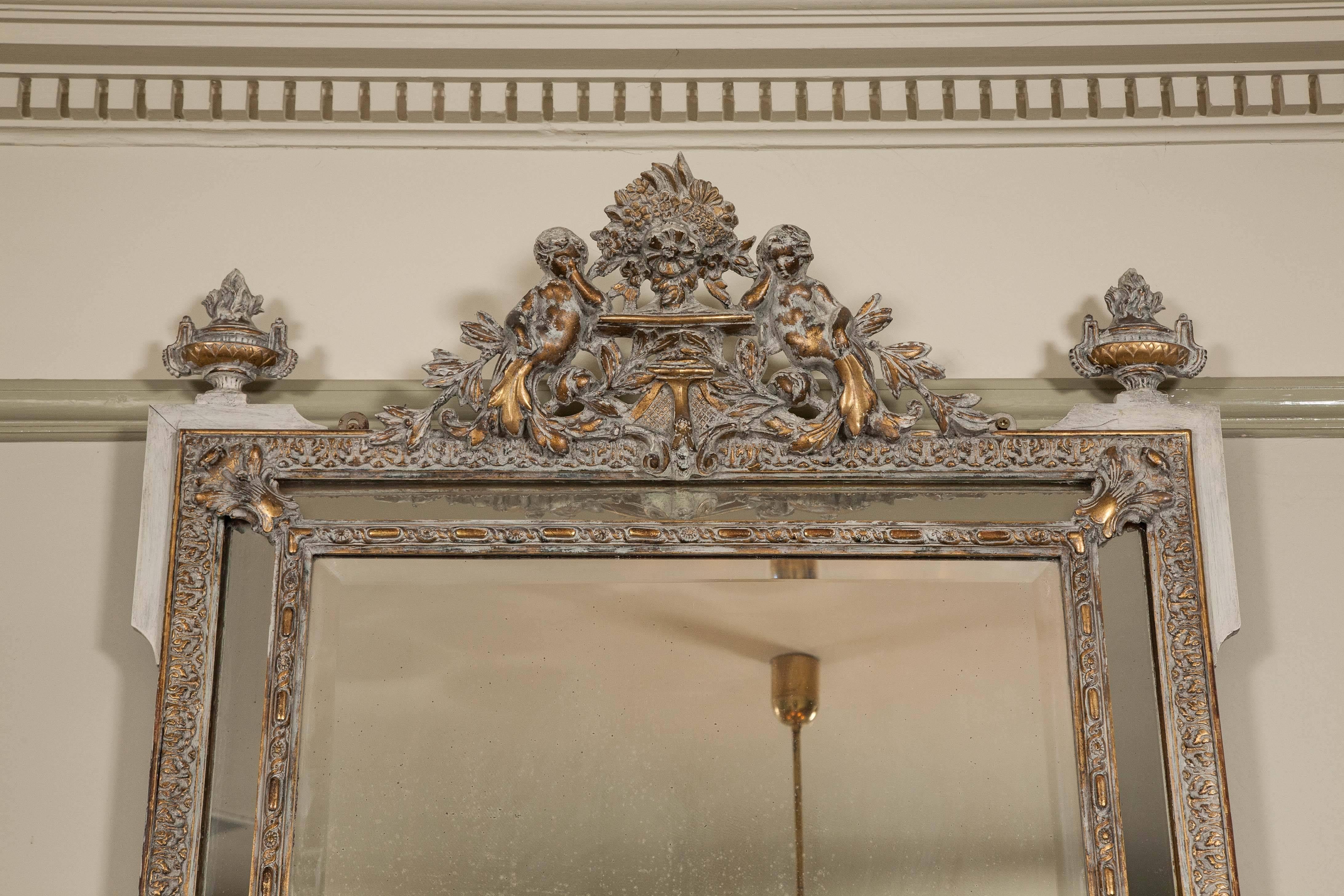 Glamorous and impactual pair of ornate mirrors featuring a double frame and an ornate design at the top.
 