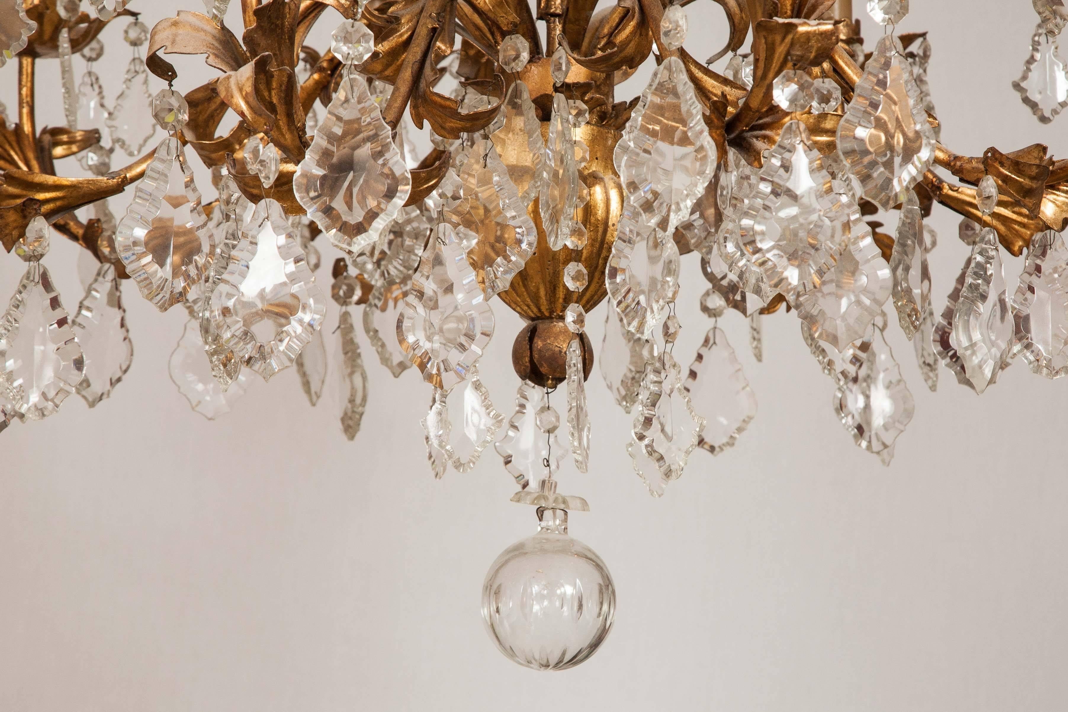 Bold and ornate this gorgeous chandelier is constructed in wrought iron finished in a brass tone with crystal drops and a glass sphere at the base.

The piece comes with a complete set of gathered green silk clip shades.

 