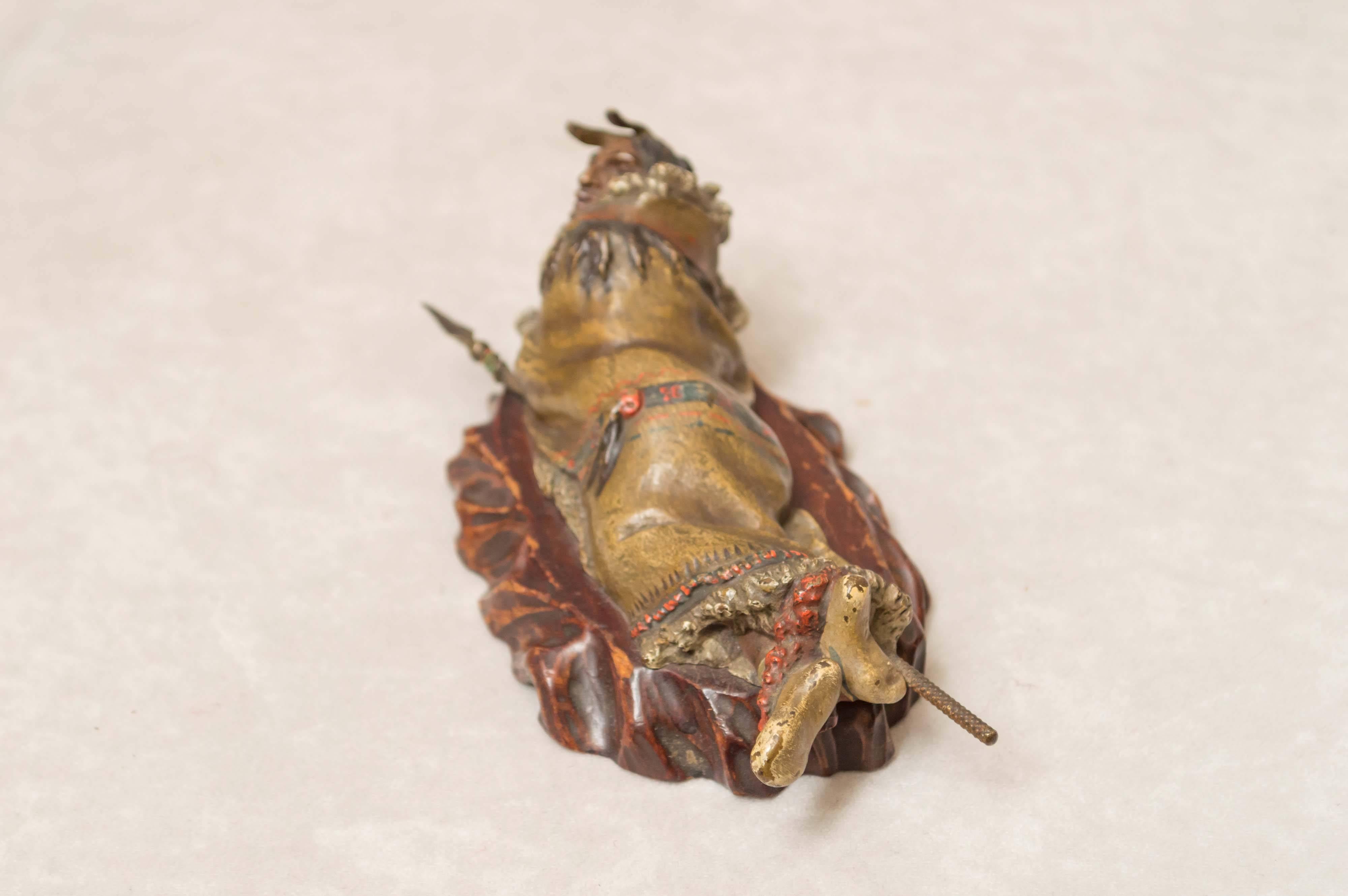 This finely detailed and meticulously painted bronze figure of a reclining Indian is another example of the fine work done by Franz Bergmann. When removing the wooden base, the signature is revealed.