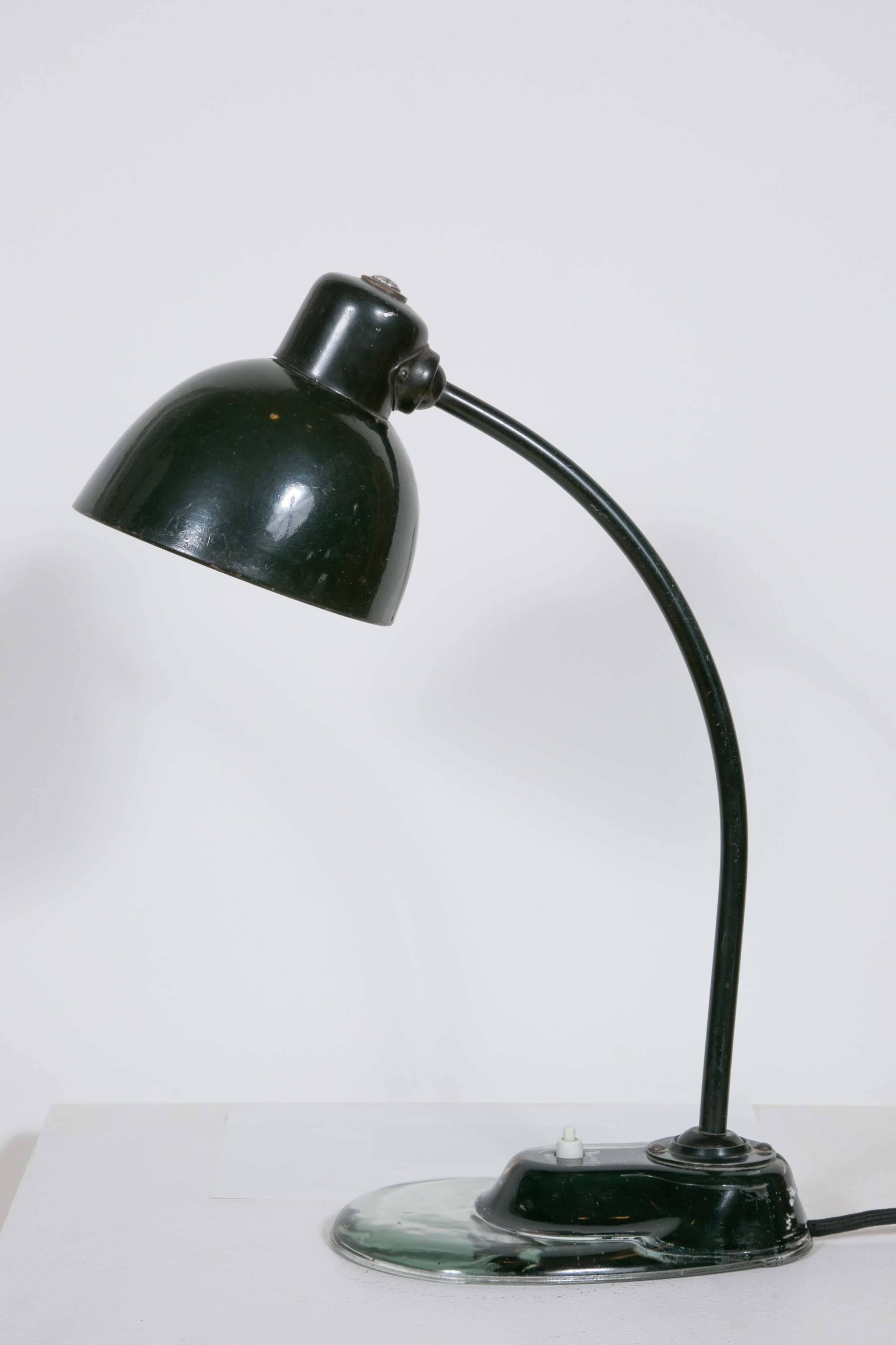 Emblematic Bauhaus desk lamp designed by Marianne Brandt and manufactured by Kandem. It has the typical glass base which makes this model the much sought after one. Original black paint. 
Fully functional.
Wired for European use.

Marianne