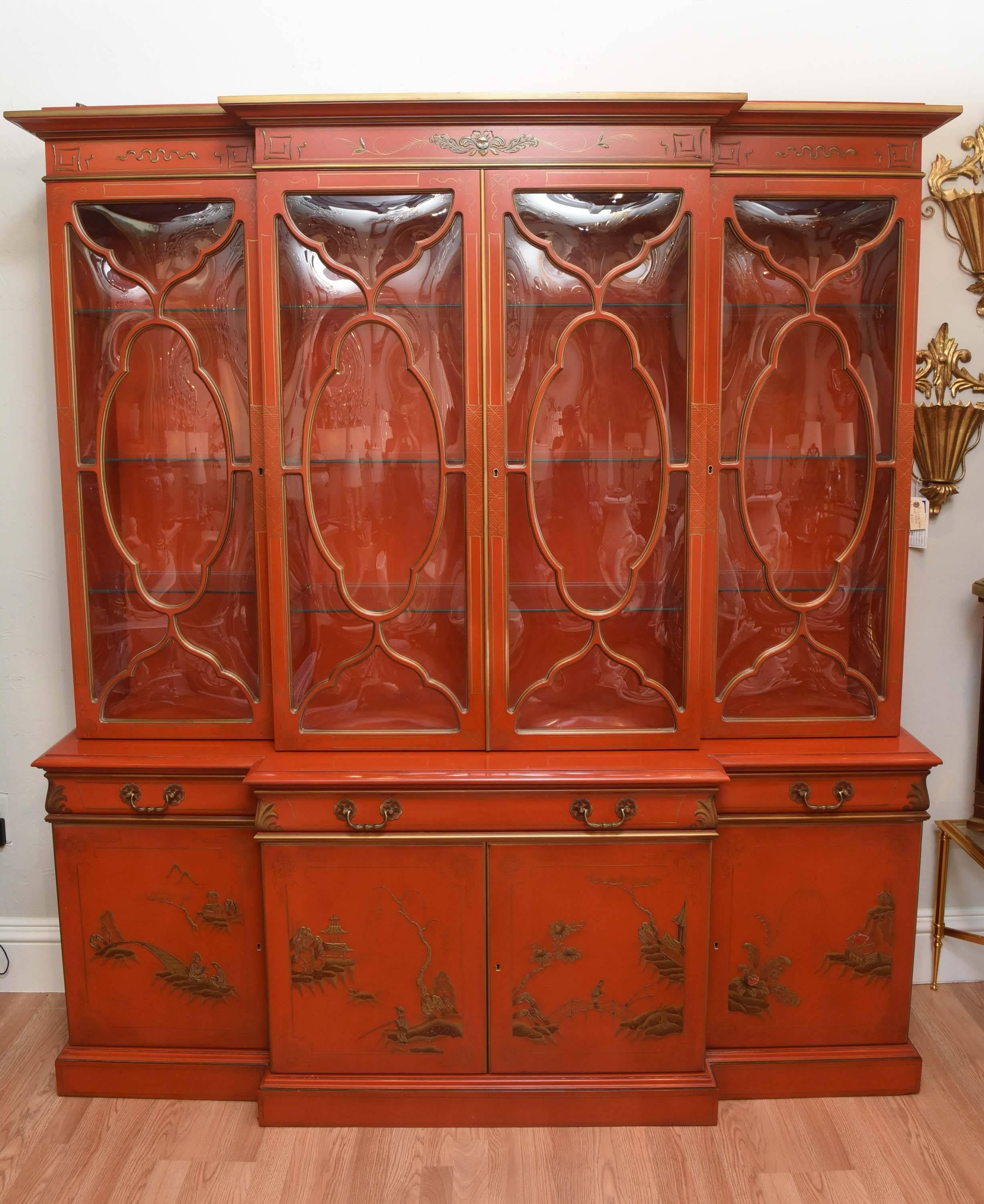 Stunning and impressive chinoiserie style breakfront. Four handblown glass doors with fretwork over three drawers. The middle drawer opens to reveal a leather top writing surface. The bottom has four doors with ample storage space.