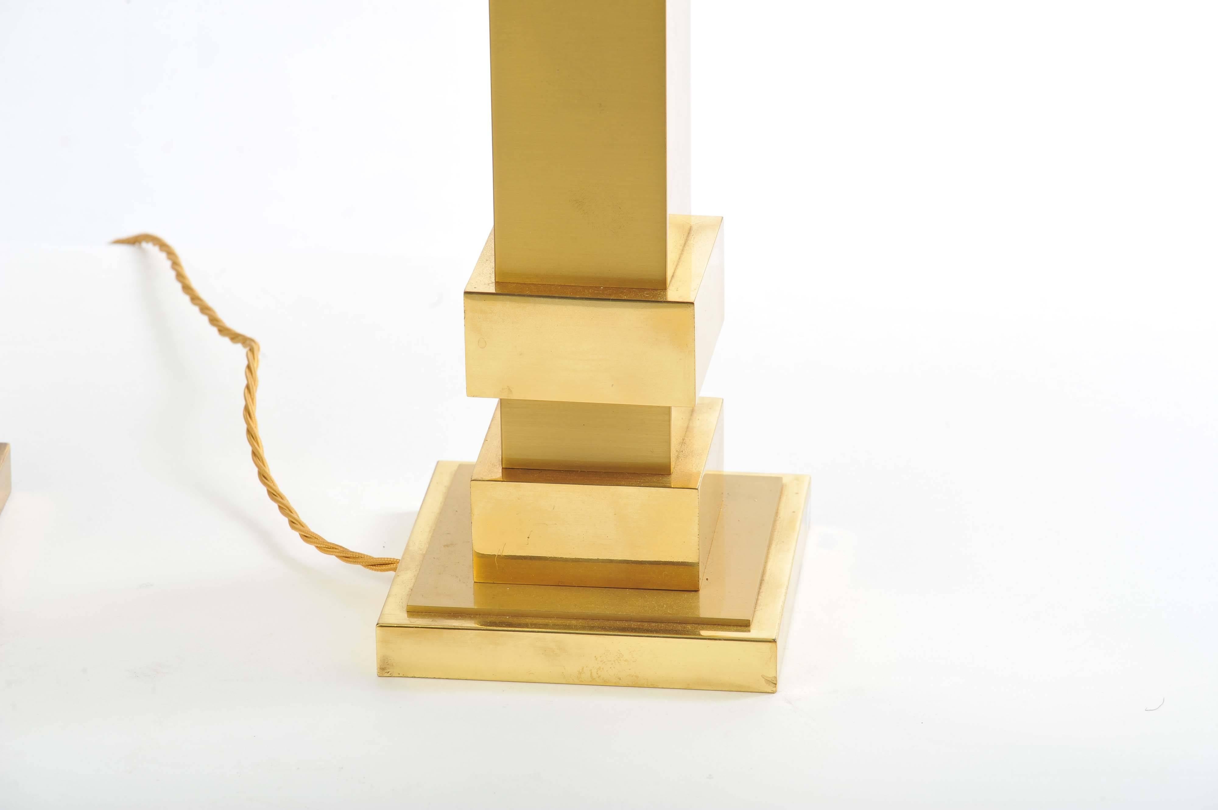 Classical geometric brass shaped pillar stands hold new rectangular silk lined shades.