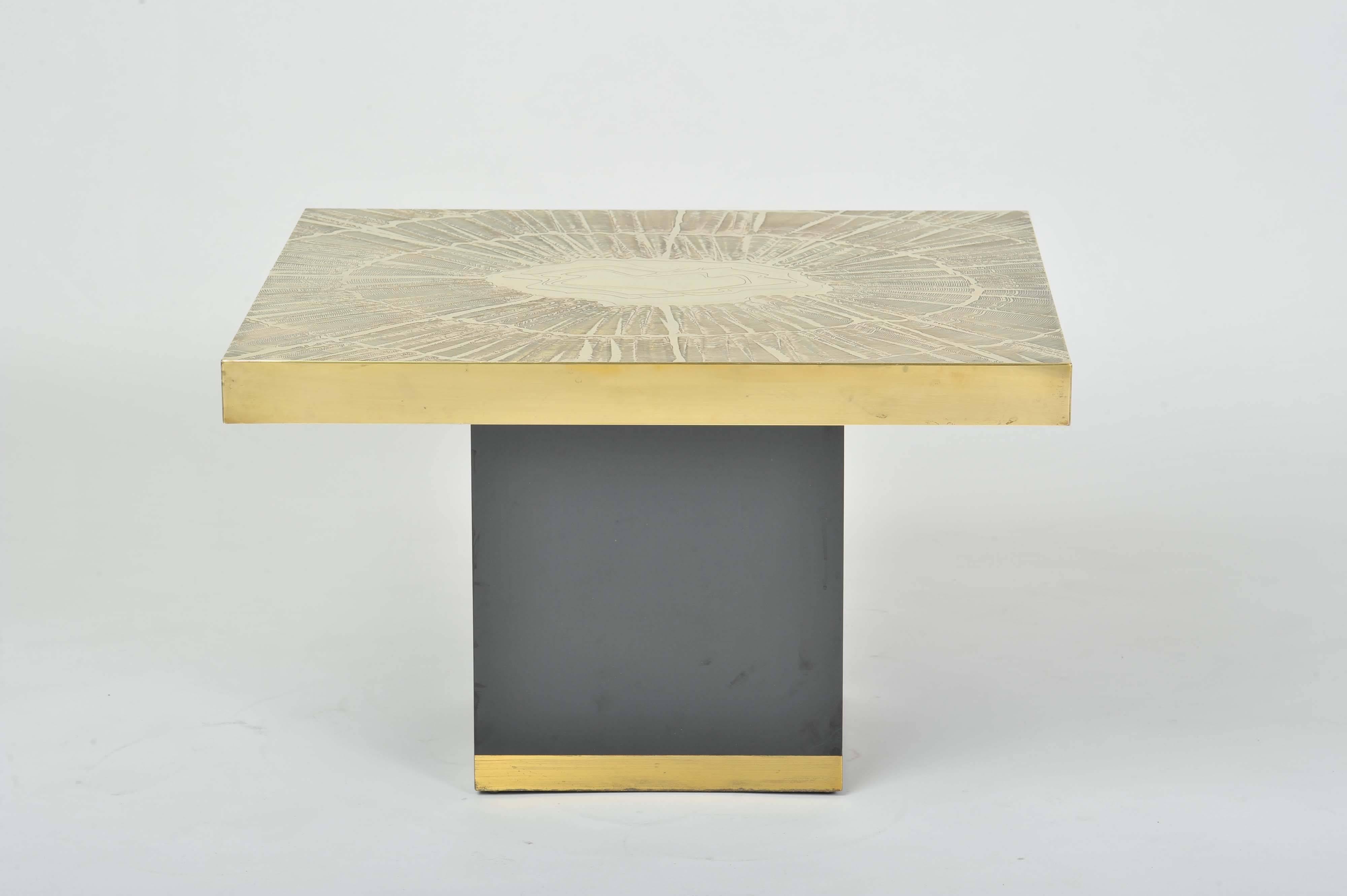 1970's Artistic brass coffee table with unique etched abstract sun ray design top. The base is black laminate on wood edged with a brass border.
Belgium origin in the style of Albert Verneuil, unsigned.
