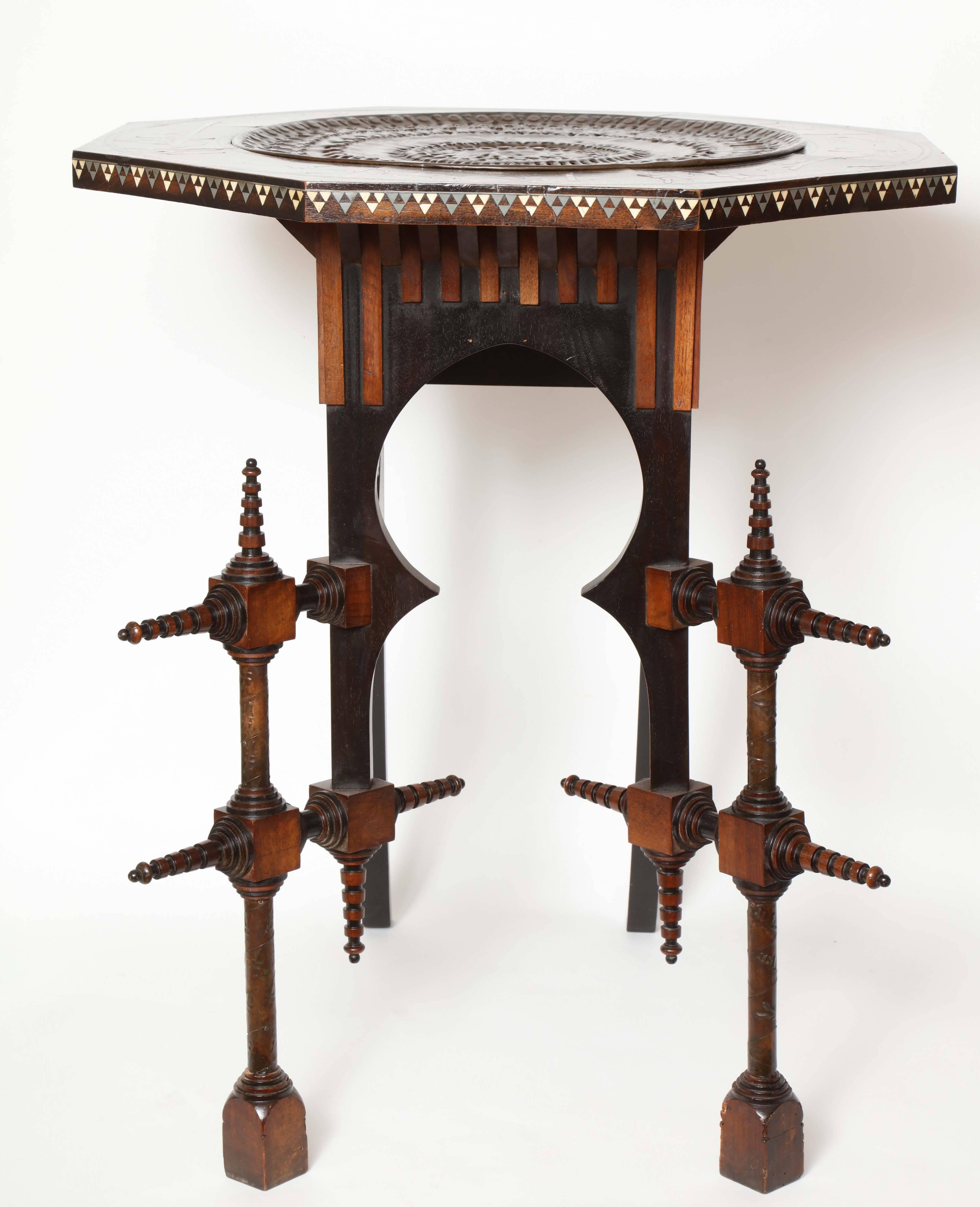 A Pewter inlaid, Italian walnut and ebonized wood, octagonal occasional table,
circa 1898, made in his Milano Studio. The table has a hand-hammered
16.75 inch round removable copper tray and stylized inlaid Pewter Characters and geometric inlay