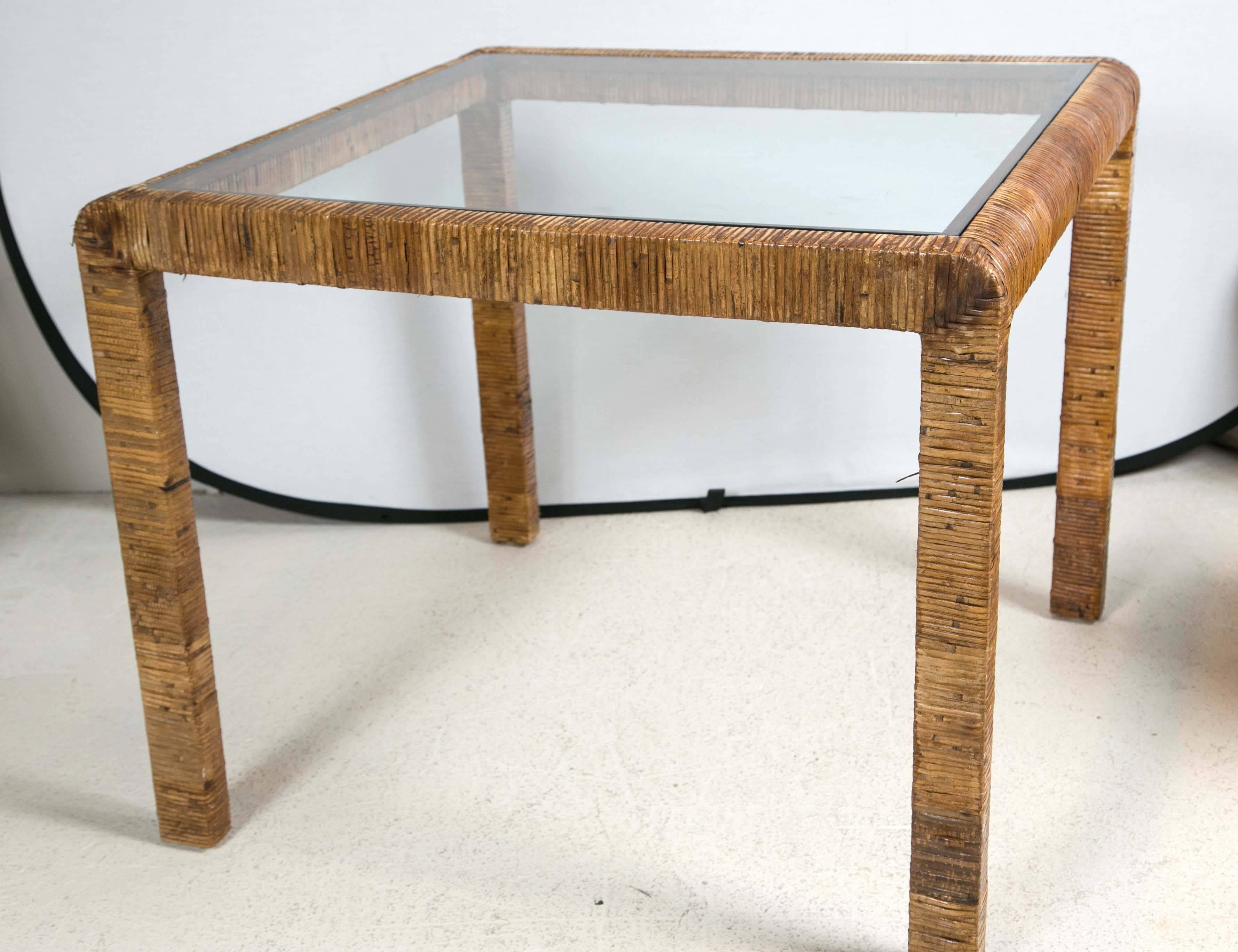 Rattan and glass card table with multicolor rattan on sides, with heavy glass inlaid top.